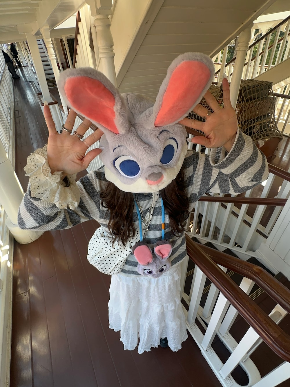 グレー系のデニムジャケット、グレー系のトップス、ホワイト系のスカートを着用したレディースの春コーディネートの2枚目の写真