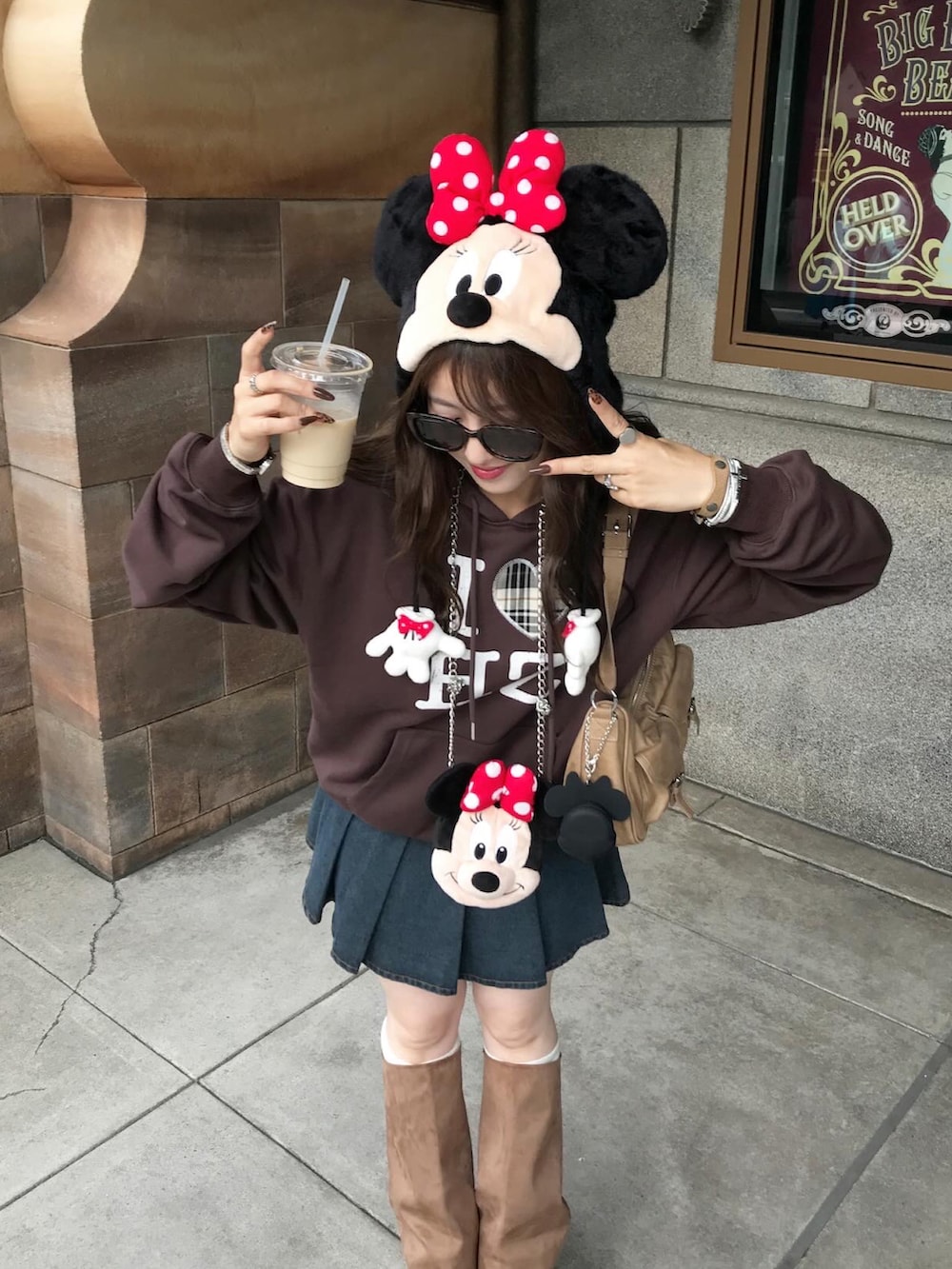 イエロー系のハンドバッグ、ブラウン系のブーツ、ブルー系のデニムスカートを着用したレディースの秋コーディネートの3枚目の写真