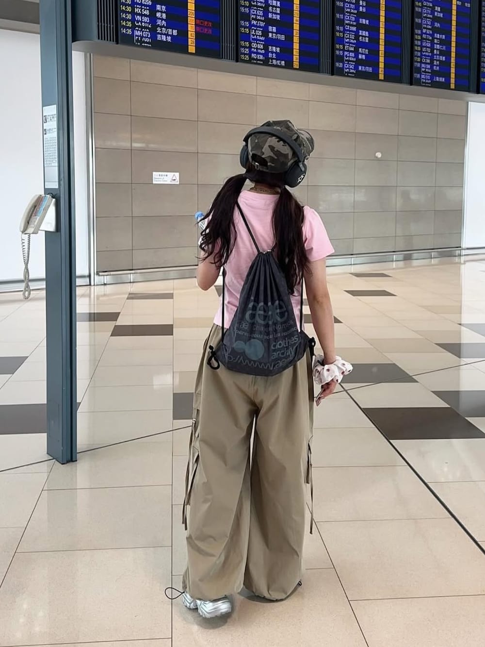 ベージュ系のカーゴパンツ、グレー系のバックパック/リュック、ピンク系のTシャツ/カットソーを着用したレディースの夏コーディネートの2枚目の写真