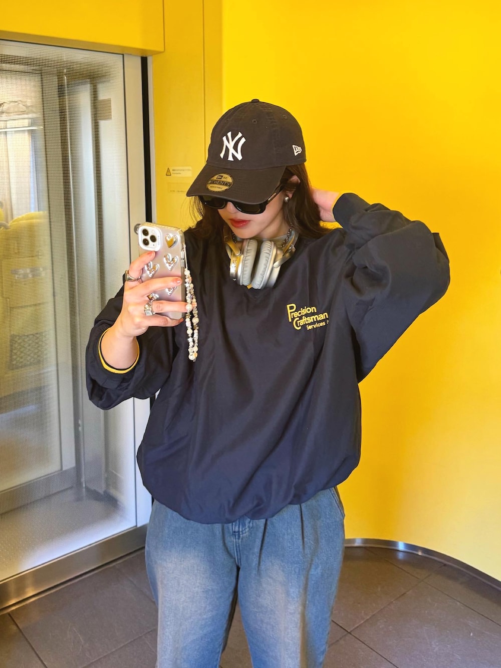 ブルー系のデニムパンツ、グレー系のスニーカー、ブルー系のキャップを着用したレディースの春コーディネートの2枚目の写真