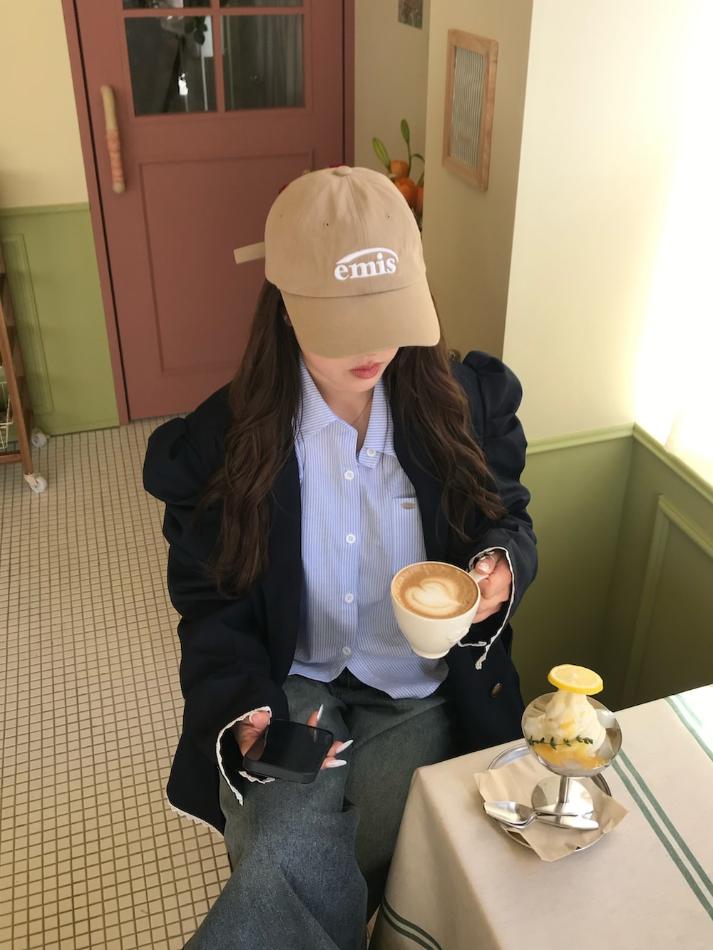 ブルー系のテーラードジャケット、ブルー系のデニムパンツ、ベージュ系のキャップを着用したレディースの春コーディネートの2枚目の写真