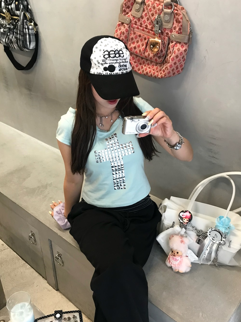 ホワイト系のバッグ、シルバー系のサンダル、ブラック系のスウェットパンツを着用したレディースの夏コーディネートの2枚目の写真