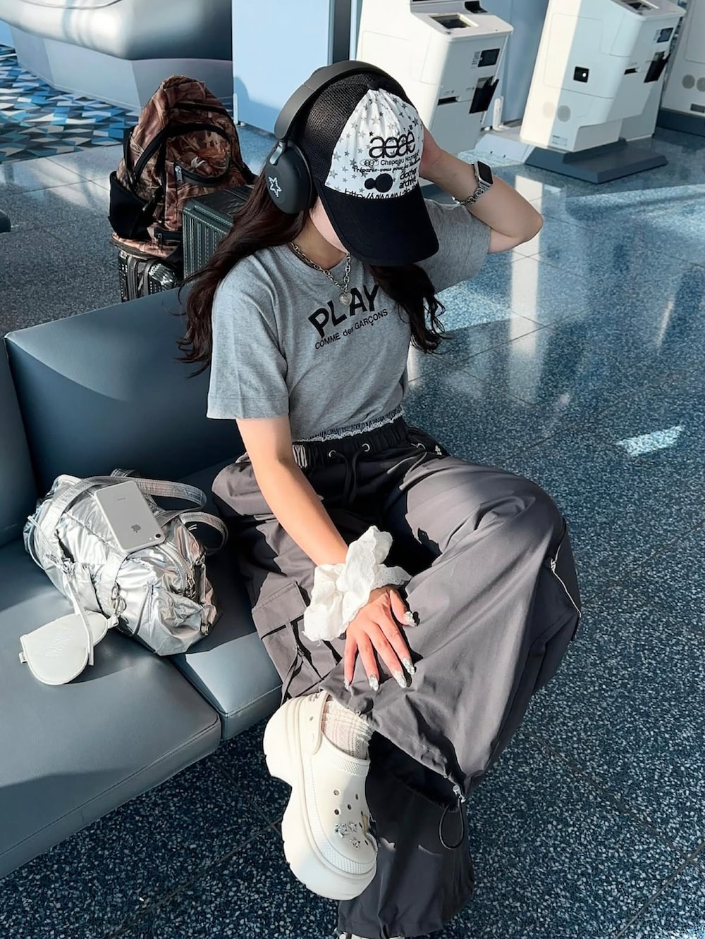 グレー系のカーゴパンツ、シルバー系のバッグ、ホワイト系のサンダルを着用したレディースの夏コーディネートの2枚目の写真