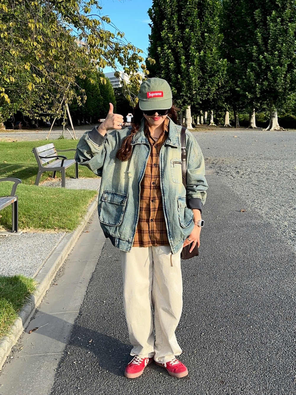 ブルー系のブルゾン、ベージュ系のパンツ、レッド系のスニーカーを着用したレディースの秋コーディネートの4枚目の写真