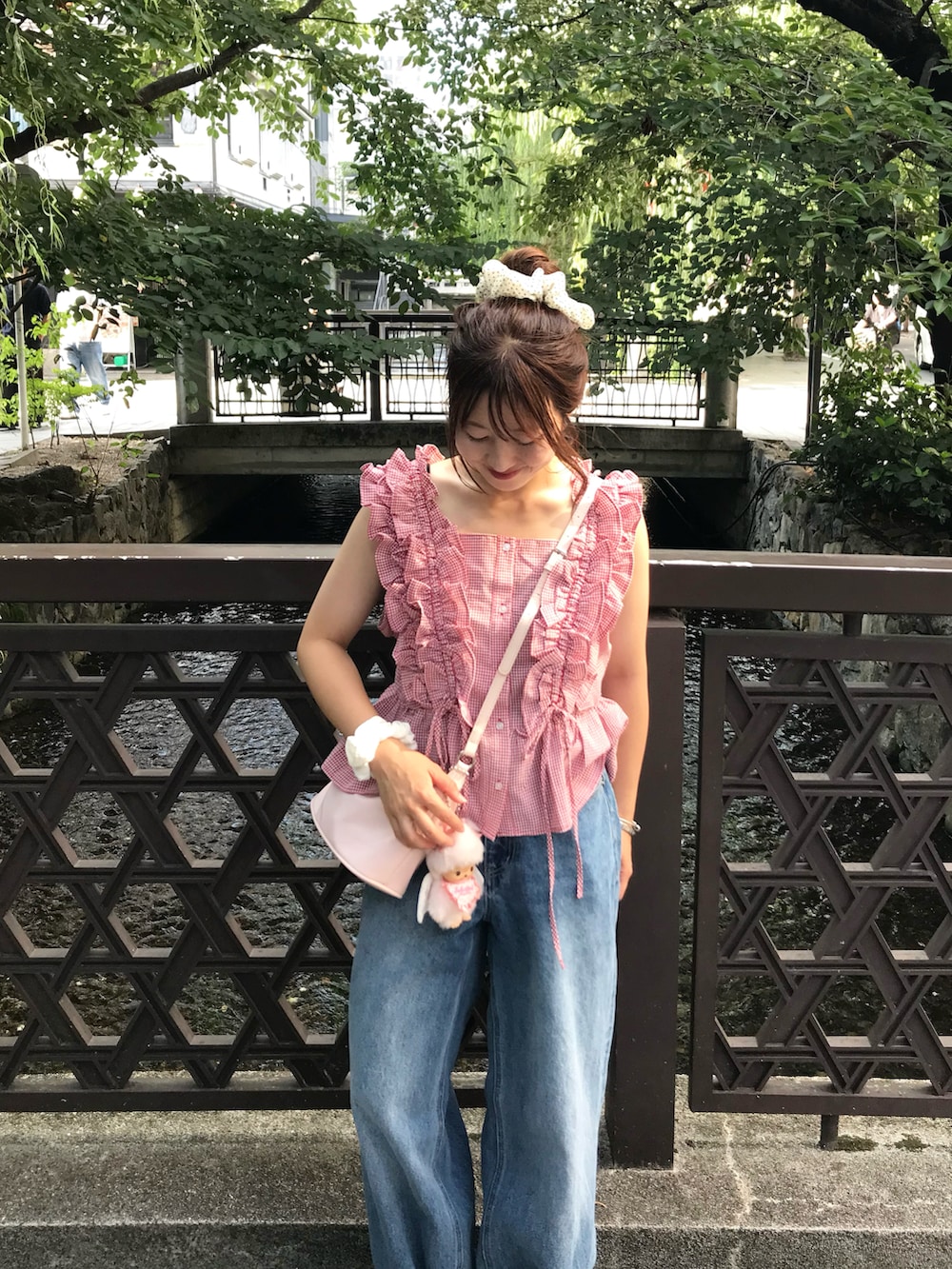 レッド系のシャツ/ブラウス、ホワイト系のスニーカー、ブルー系のデニムパンツを着用したレディースの夏コーディネートの3枚目の写真