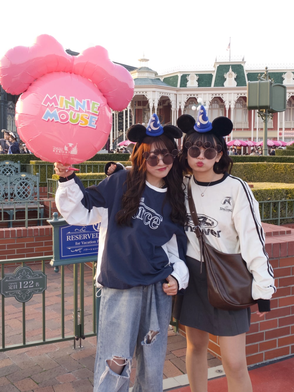 ホワイト系のスニーカー、ブルー系のトップス、ブルー系のデニムパンツを着用したレディースの秋コーディネートの2枚目の写真