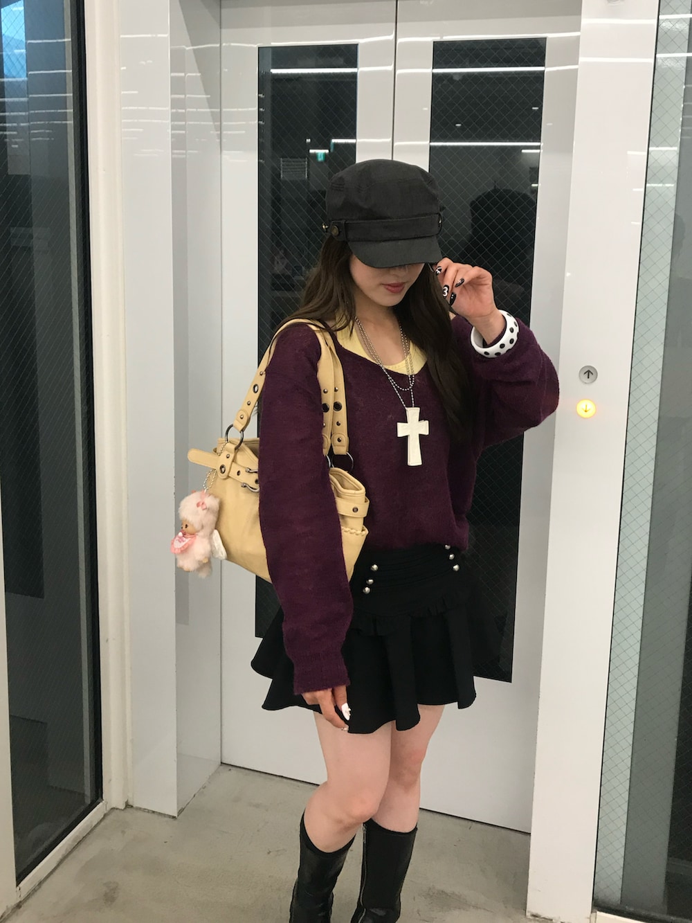 ブラック系のブーツ、イエロー系のバッグ、グリーン系のTシャツ/カットソーを着用したレディースの秋コーディネートの3枚目の写真
