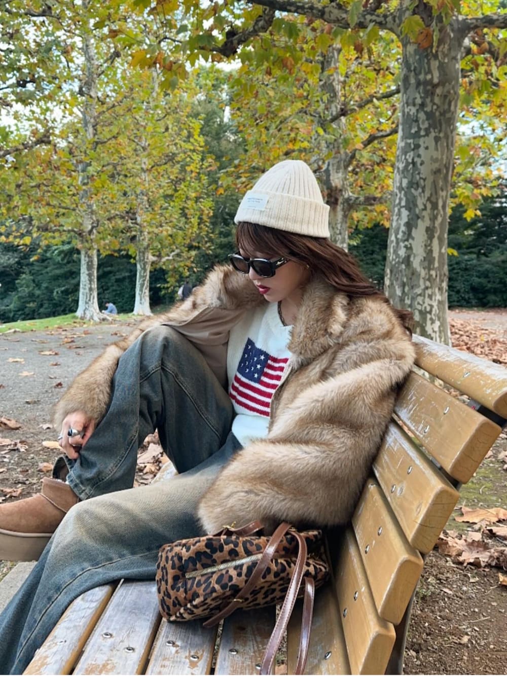 ブラウン系のブルゾン、ホワイト系のニット/セーター、ブルー系のデニムパンツを着用したレディースの秋コーディネートの2枚目の写真