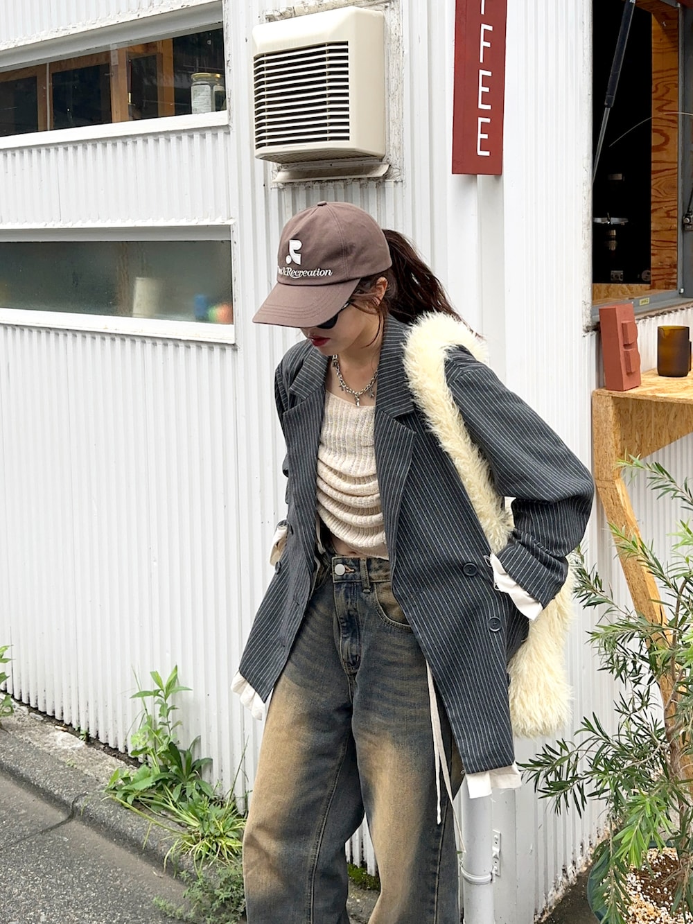 ベージュ系のニット/セーター、ブルー系のデニムパンツ、グレー系のジャケット/アウターを着用したレディースの秋コーディネートの3枚目の写真