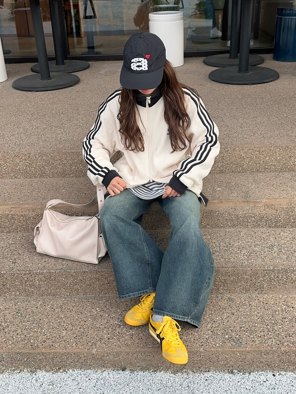 ホワイト系のジャージ、ブルー系のデニムパンツ、イエロー系のスニーカーを着用したレディースの春コーディネートの5枚目の写真