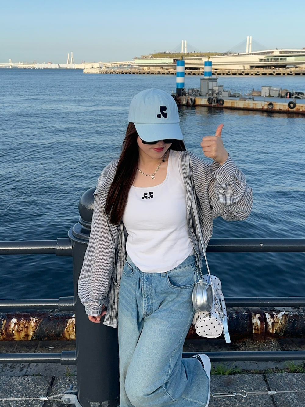 ホワイト系のTシャツ/カットソー、ホワイト系のシャツ/ブラウス、ブルー系のデニムパンツを着用したレディースの春コーディネートの2枚目の写真