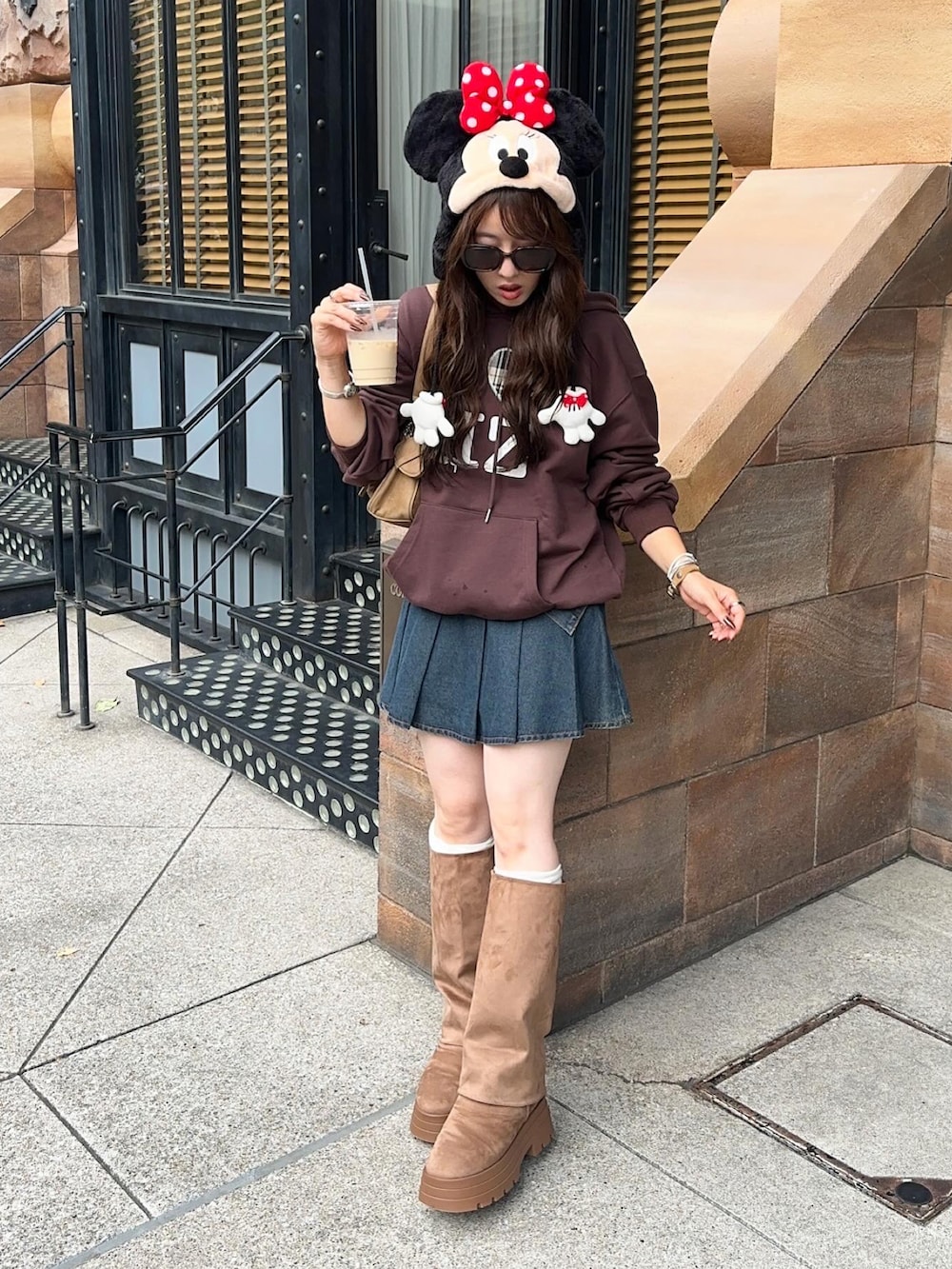 イエロー系のハンドバッグ、ブラウン系のブーツ、ブルー系のデニムスカートを着用したレディースの秋コーディネートの4枚目の写真