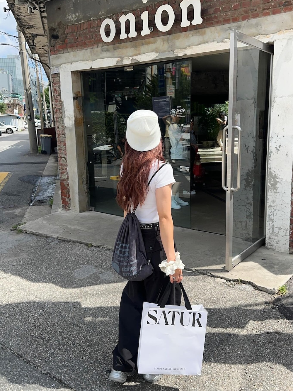 シルバー系のサンダル、ホワイト系のTシャツ/カットソー、ブラック系のパンツを着用したレディースの秋コーディネートの2枚目の写真