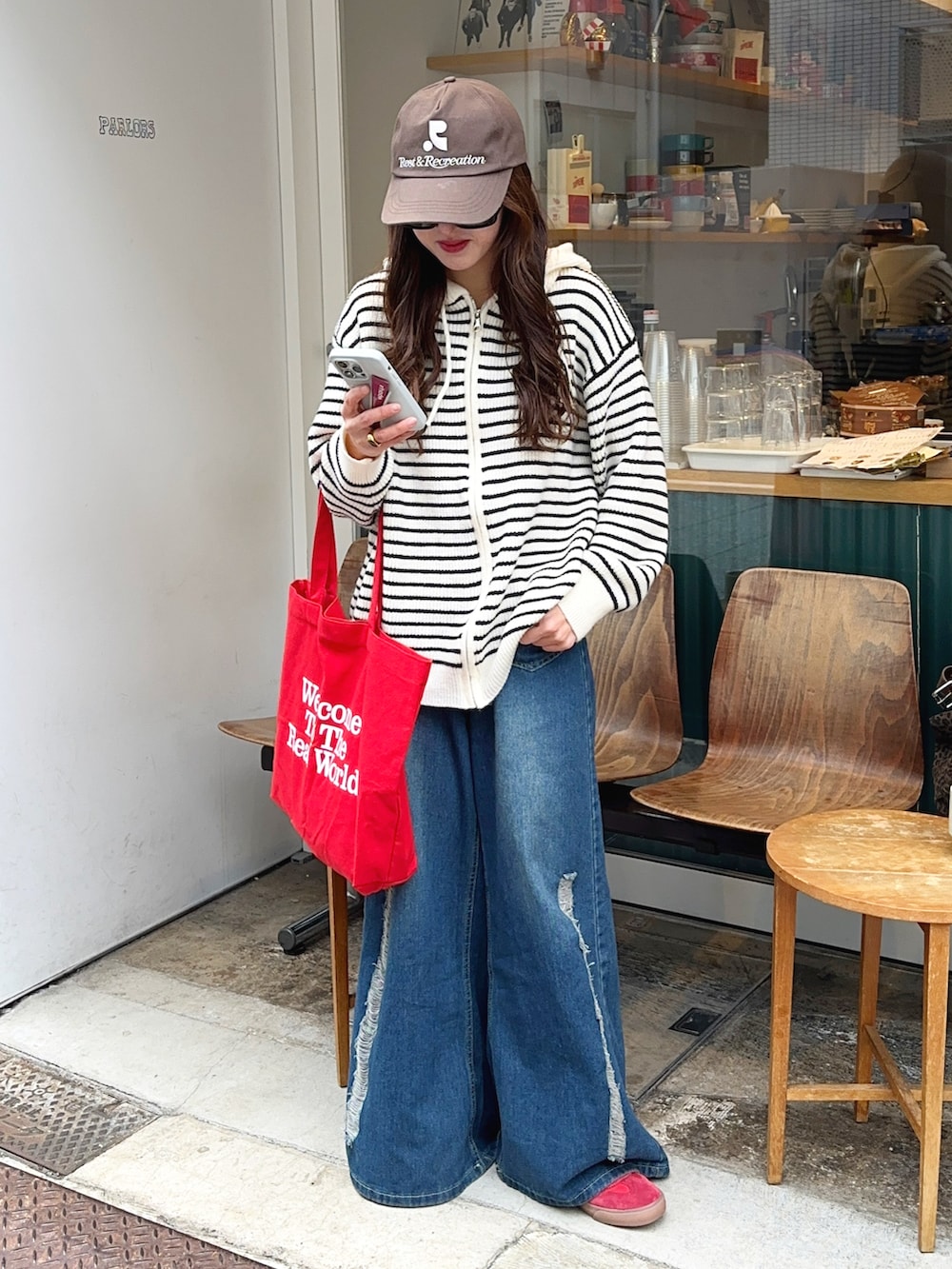 レッド系のスニーカー、ブラウン系のキャップを着用したレディースの冬コーディネートの2枚目の写真