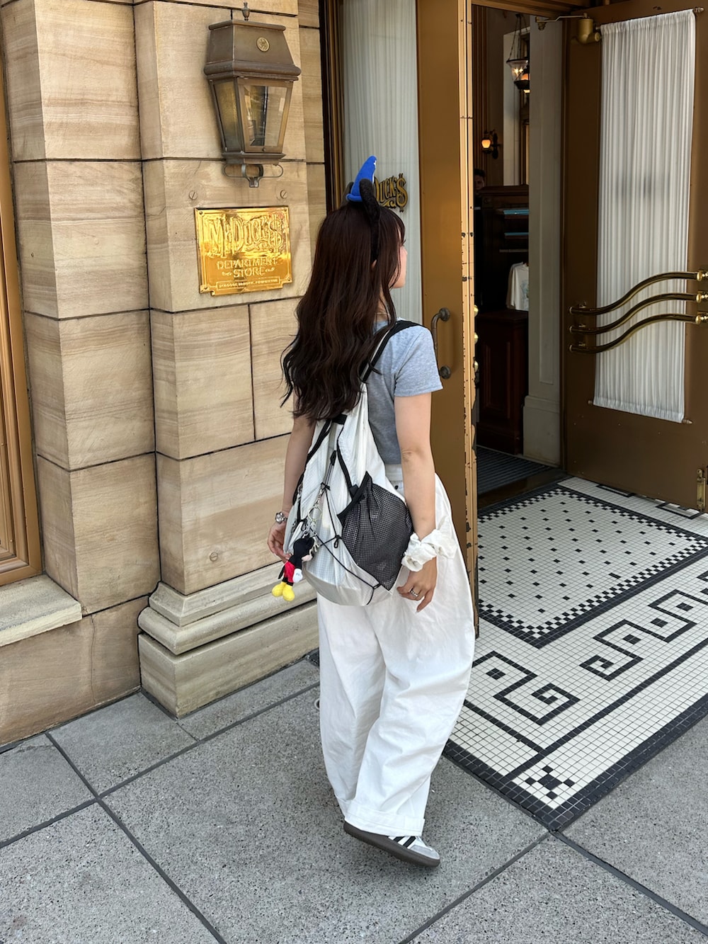ホワイト系のスニーカー、グレー系のTシャツ/カットソー、ホワイト系のパンツを着用したレディースの春コーディネートの3枚目の写真