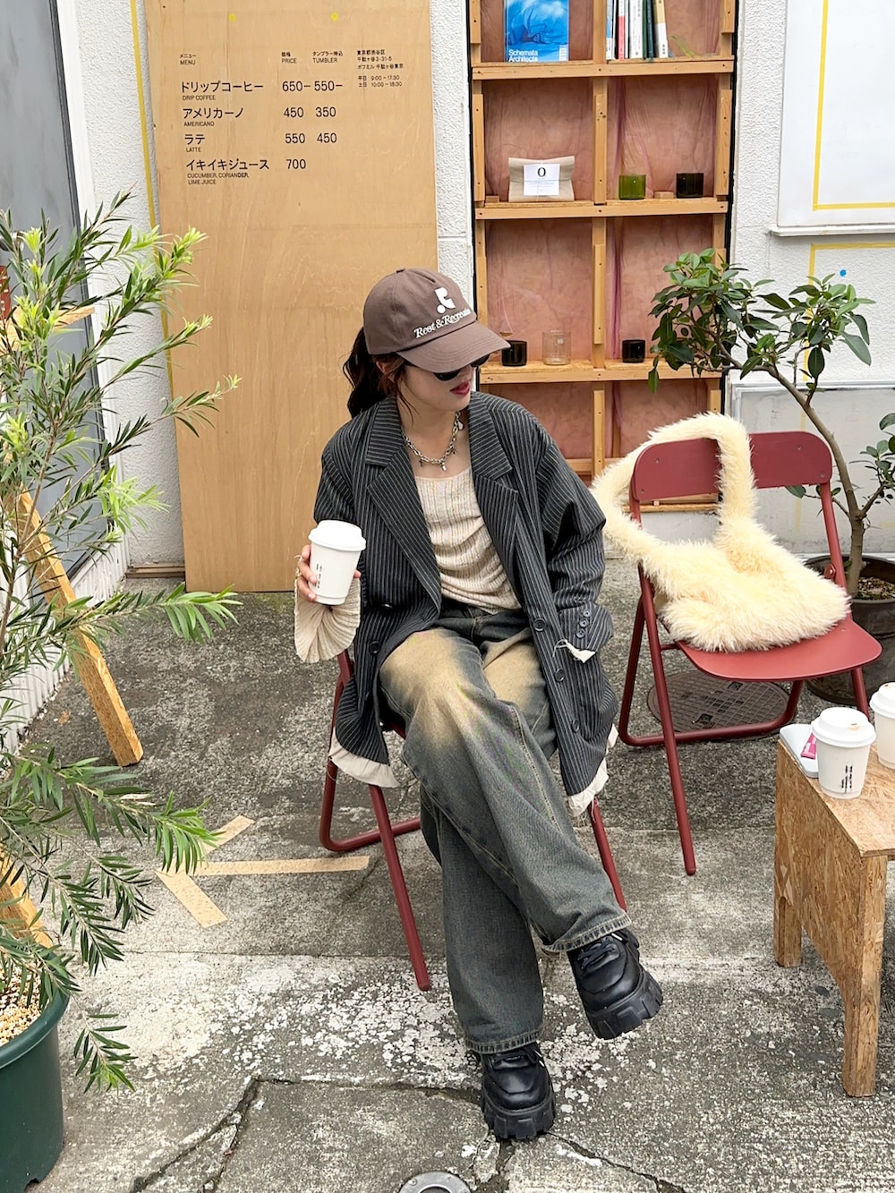 ベージュ系のニット/セーター、ブルー系のデニムパンツ、グレー系のジャケット/アウターを着用したレディースの秋コーディネートの4枚目の写真