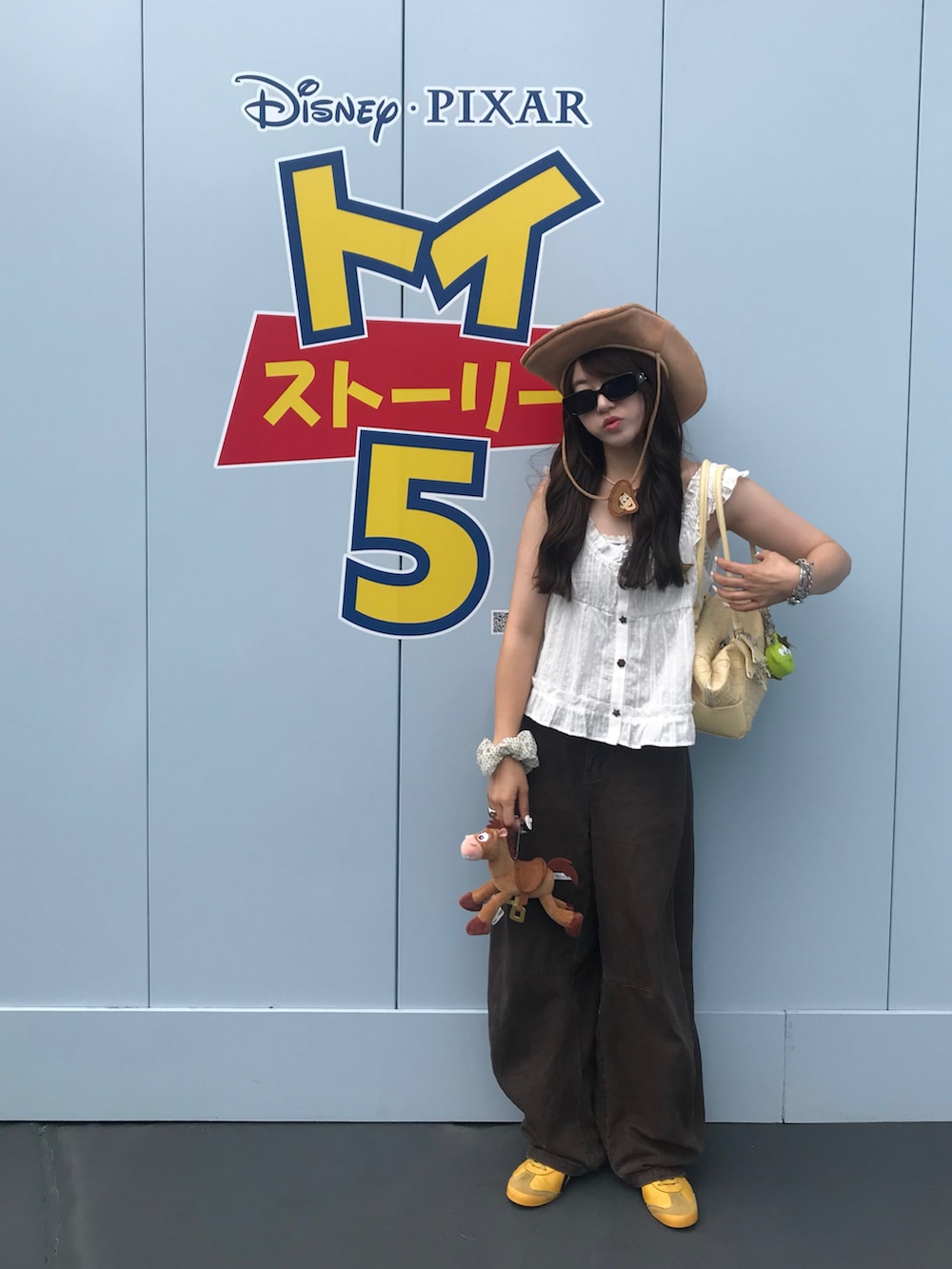 ホワイト系のシャツ/ブラウス、ブラウン系のデニムパンツ、イエロー系のスニーカーを着用したレディースの夏コーディネートの2枚目の写真