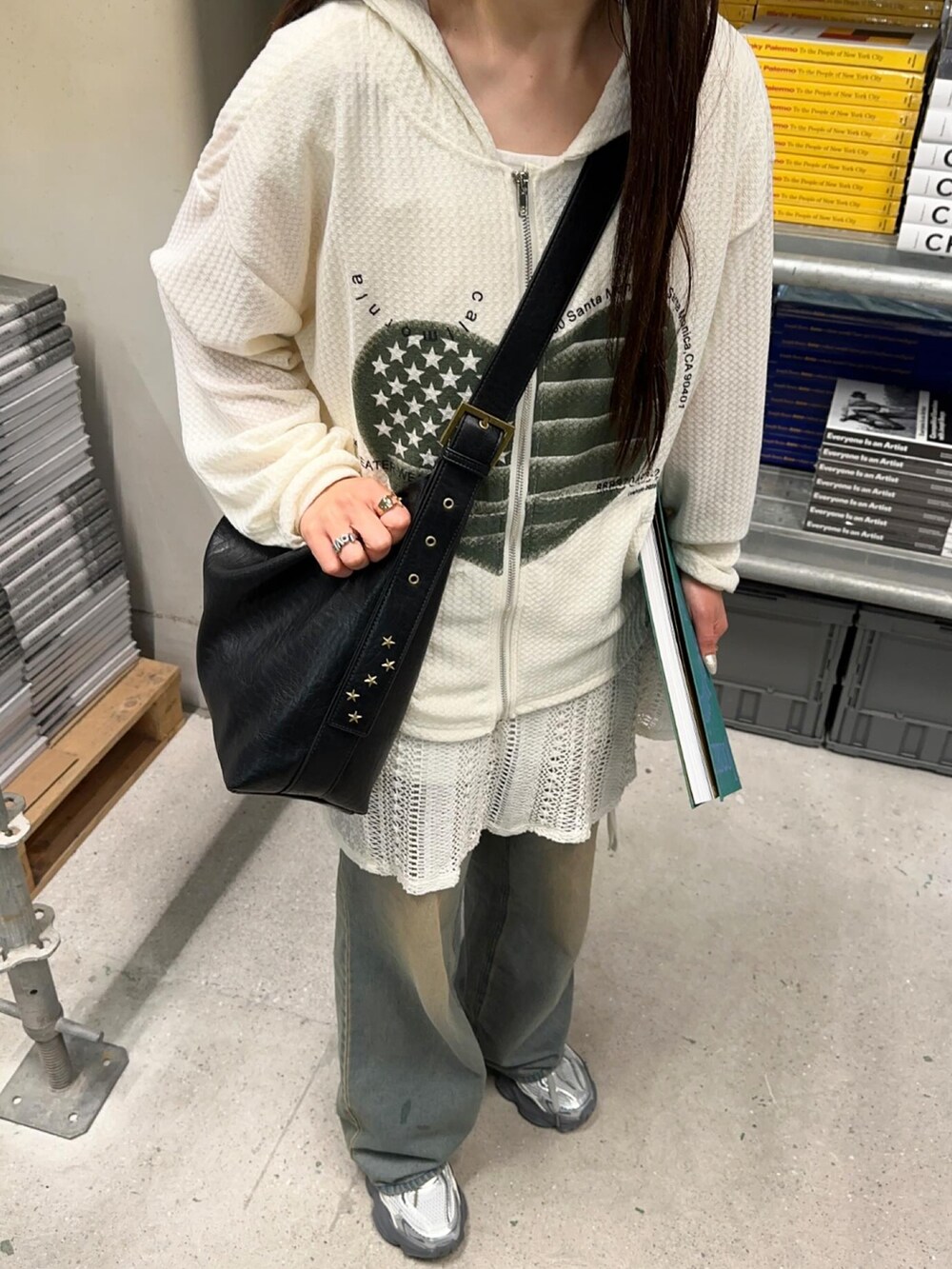 ブルー系のデニムパンツ、ホワイト系のパーカー、ブラック系のショルダーバッグを着用したレディースの春コーディネートの2枚目の写真