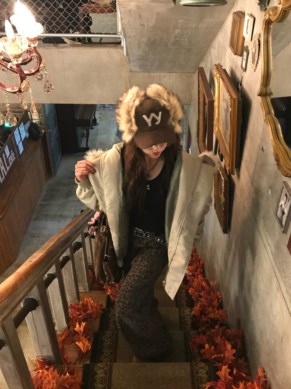 ホワイト系のブルゾン、ブラック系のTシャツ/カットソー、ブラウン系のパンツを着用したレディースの秋コーディネートの2枚目の写真