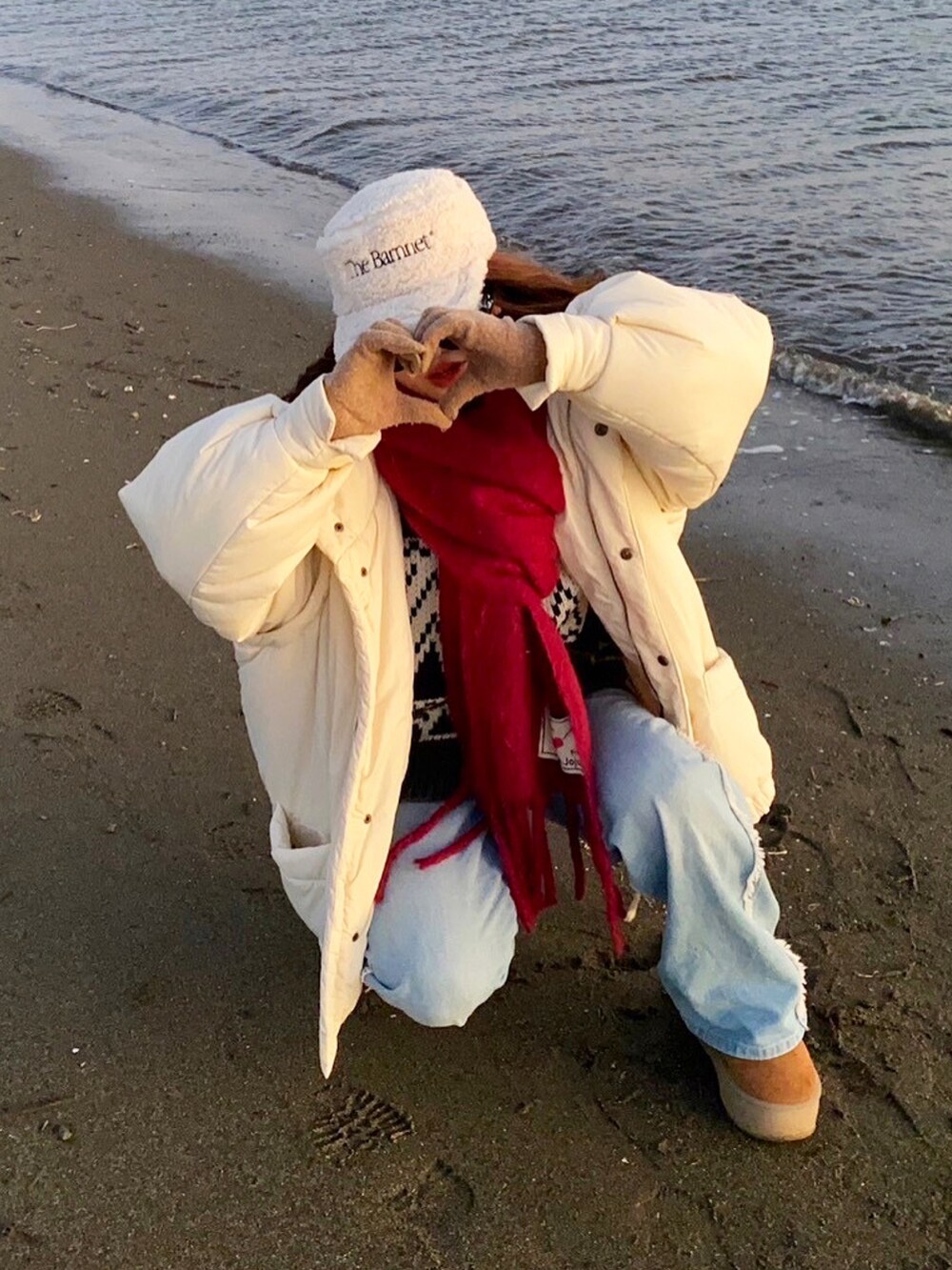 ホワイト系のブルゾン、グレー系のカーディガン/ボレロ、パープル系のマフラーを着用したレディースの冬コーディネートの2枚目の写真