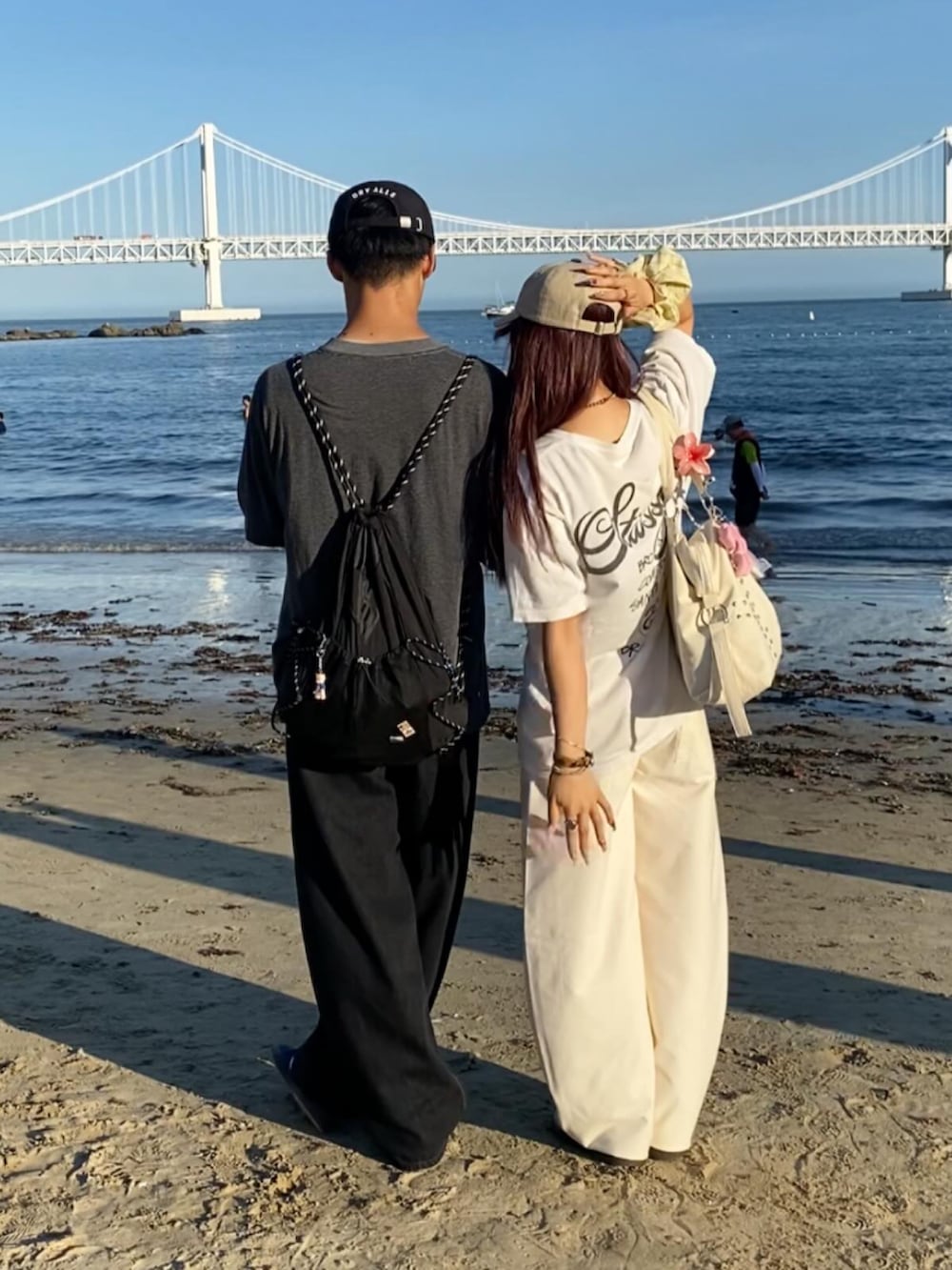 ブラック系のスニーカー、ホワイト系のTシャツ/カットソー、ホワイト系のパンツを着用したレディースの夏コーディネートの2枚目の写真