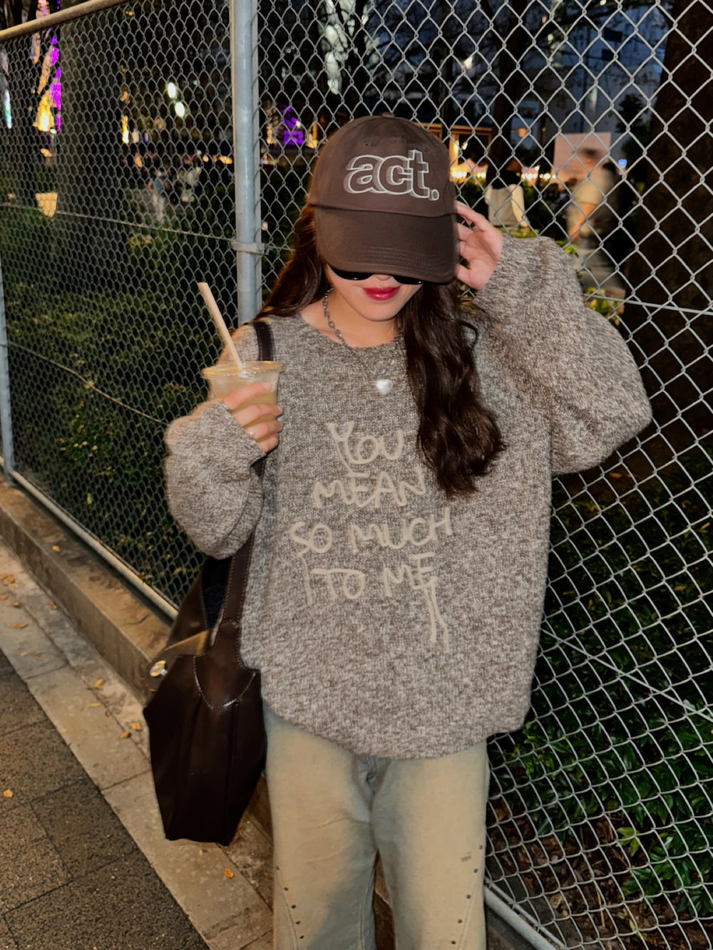 ブラウン系のニット/セーター、ブルー系のデニムパンツを着用したレディースの秋コーディネートの2枚目の写真