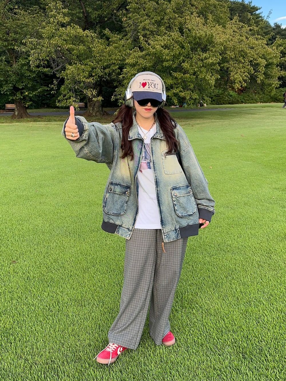 レッド系のスニーカー、ブルー系のブルゾン、ホワイト系のTシャツ/カットソーを着用したレディースの秋コーディネートの5枚目の写真