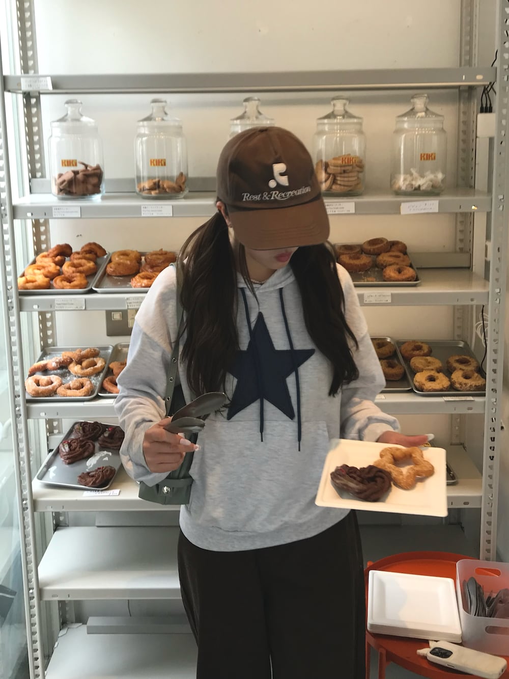 グレー系のパーカー、ブラウン系のデニムパンツ、ブラウン系のキャップを着用したレディースの冬コーディネートの3枚目の写真