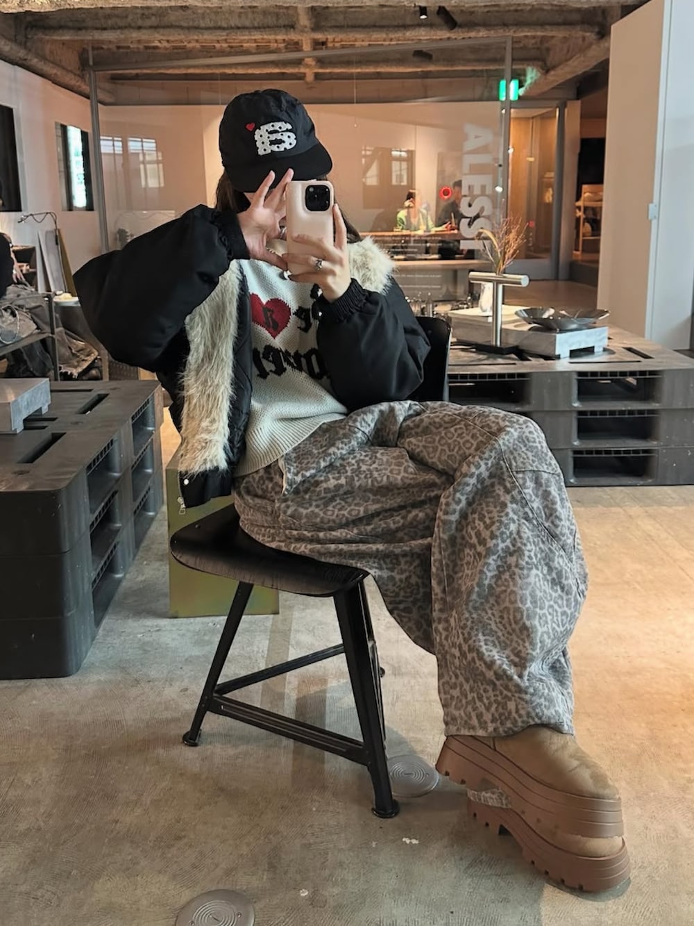 ホワイト系のニット/セーター、ブラウン系のブーツ、グレー系のデニムパンツを着用したレディースの秋コーディネートの2枚目の写真