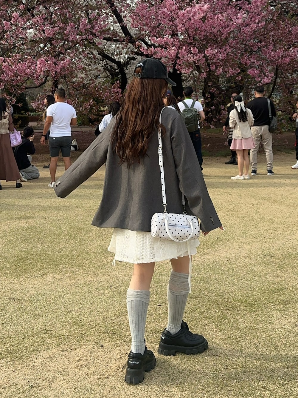 グレー系のテーラードジャケット、ブラック系のスニーカー、グレー系のソックス/靴下を着用したレディースの春コーディネートの4枚目の写真