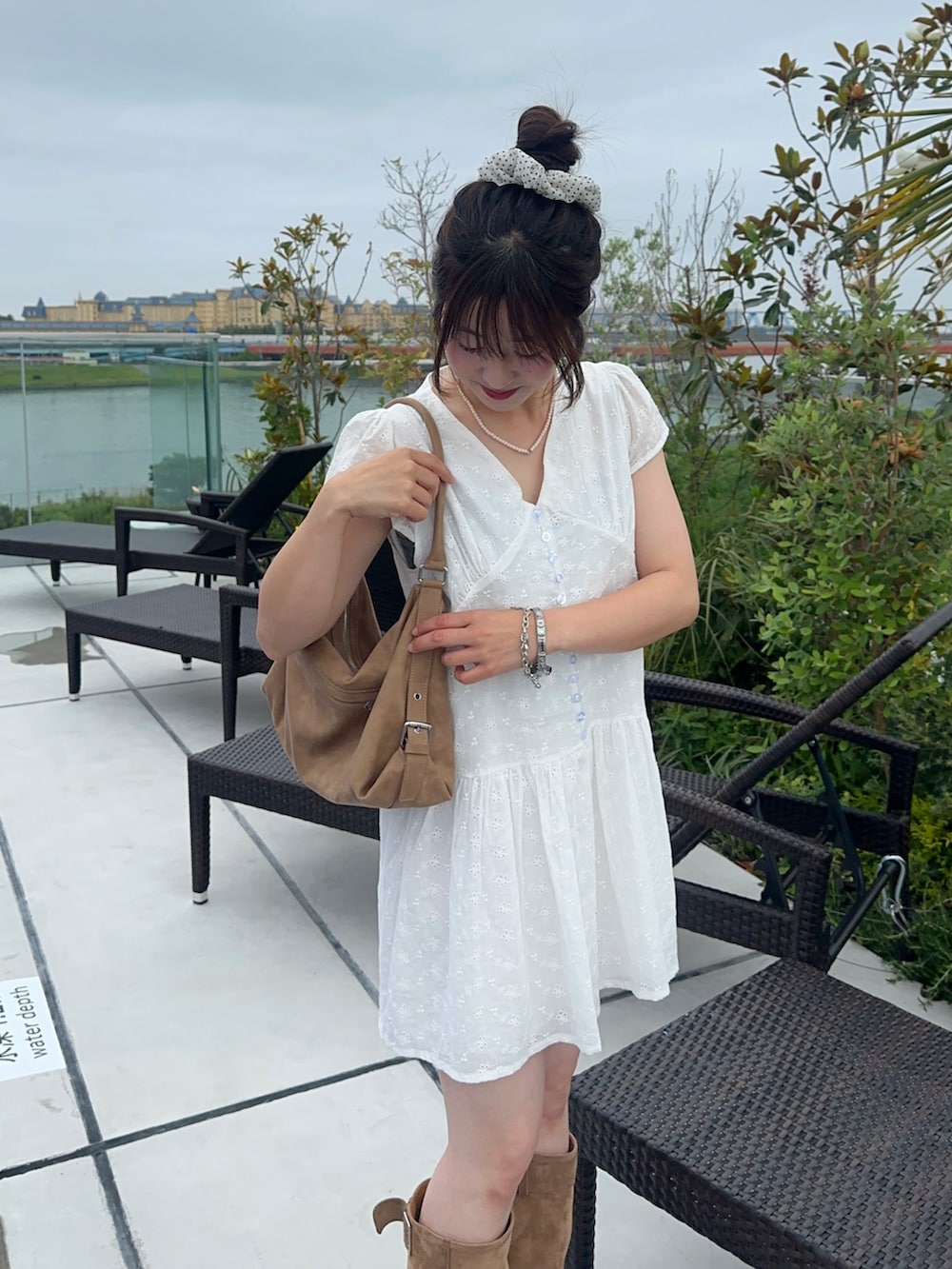 ホワイト系のワンピース、ベージュ系のバッグを着用したレディースの夏コーディネートの2枚目の写真