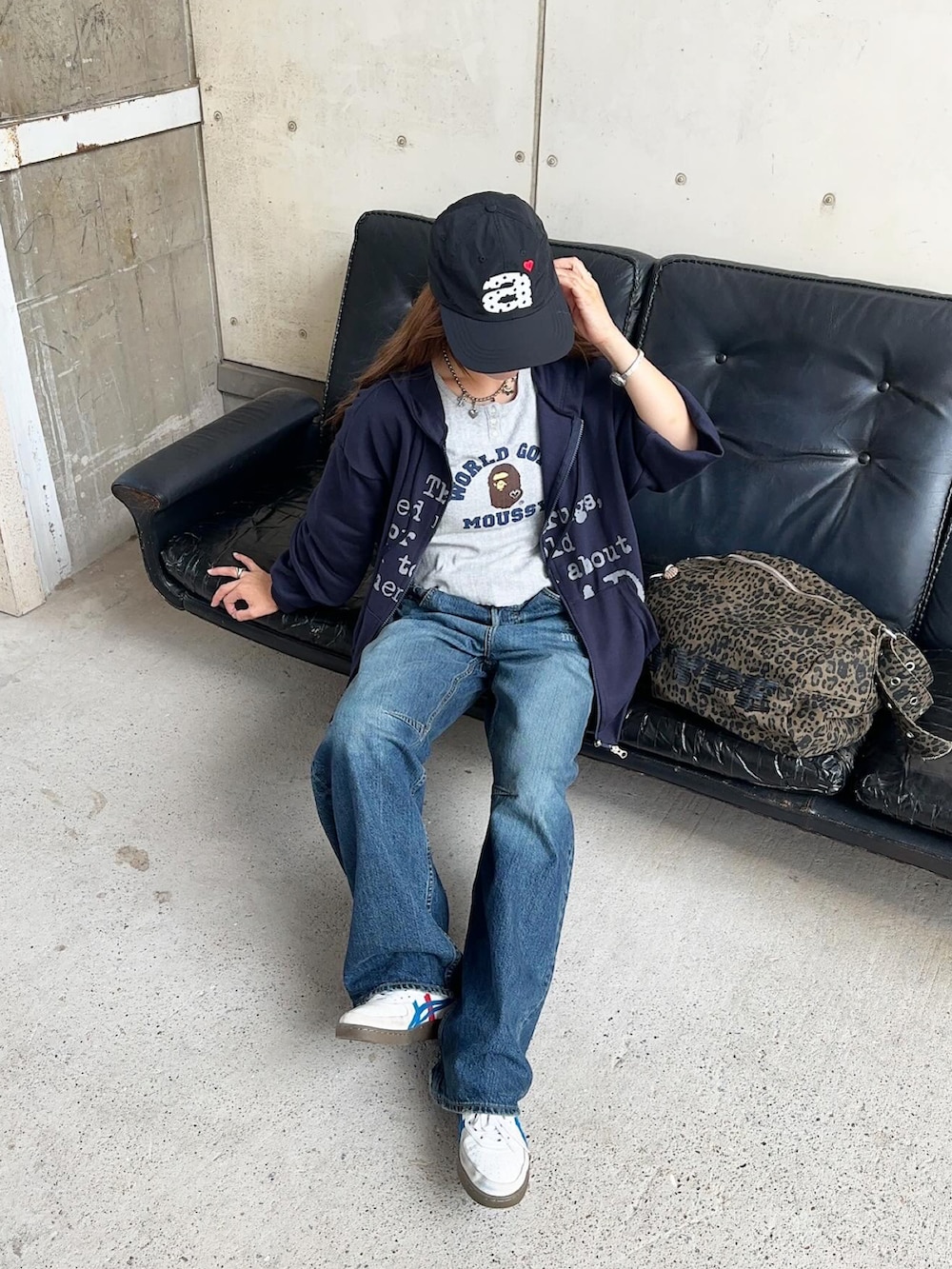 ブラウン系のショルダーバッグ、グレー系のTシャツ/カットソー、ブルー系のパーカーを着用したレディースの秋コーディネートの2枚目の写真