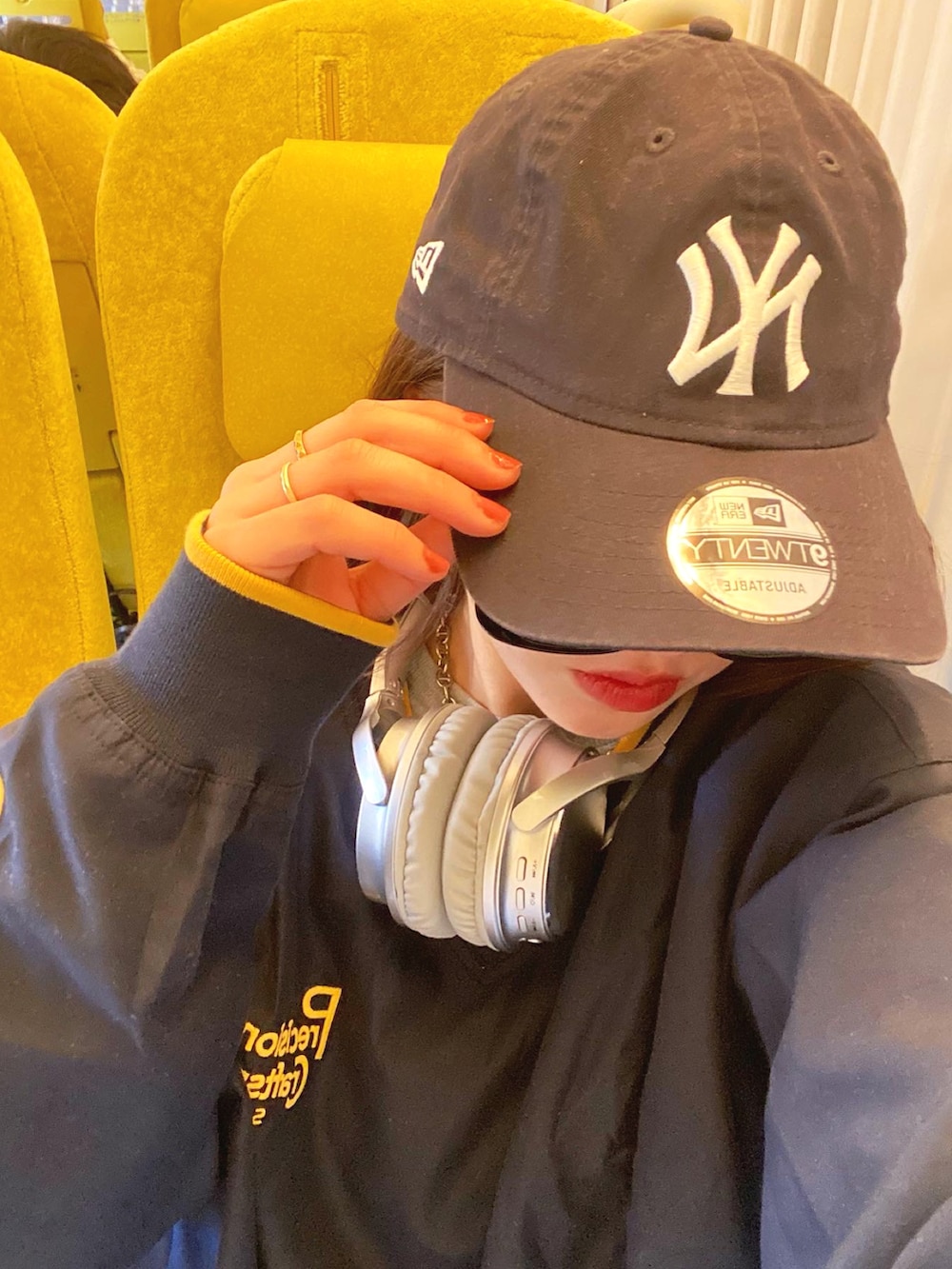 ブルー系のデニムパンツ、グレー系のスニーカー、ブルー系のキャップを着用したレディースの春コーディネートの3枚目の写真