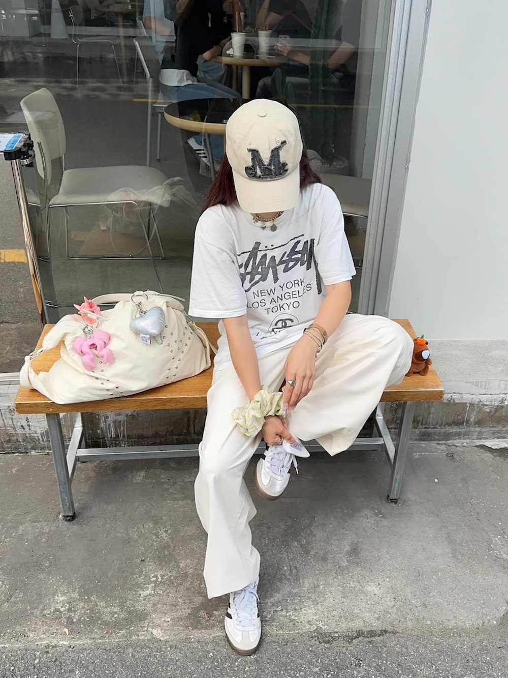 ブラック系のスニーカー、ホワイト系のTシャツ/カットソー、ホワイト系のパンツを着用したレディースの夏コーディネートの3枚目の写真