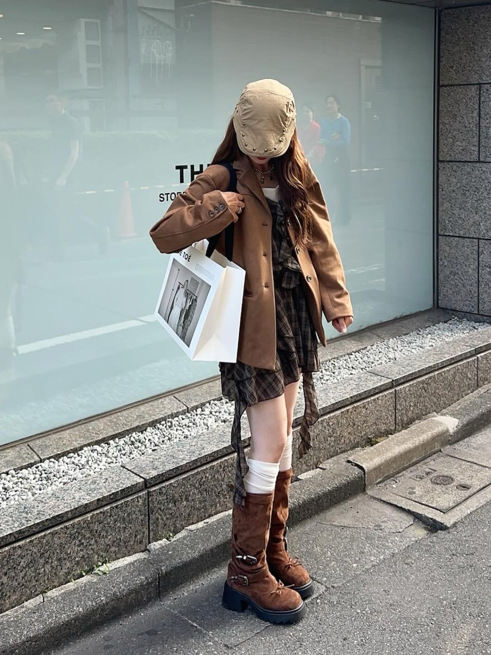 イエロー系のテーラードジャケット、ブラウン系のブーツ、ブラウン系のワンピース/ドレスを着用したレディースの秋コーディネートの3枚目の写真