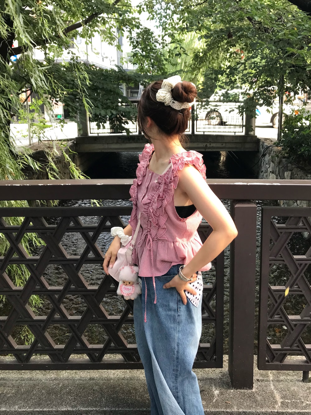 レッド系のシャツ/ブラウス、ホワイト系のスニーカー、ブルー系のデニムパンツを着用したレディースの夏コーディネートの2枚目の写真