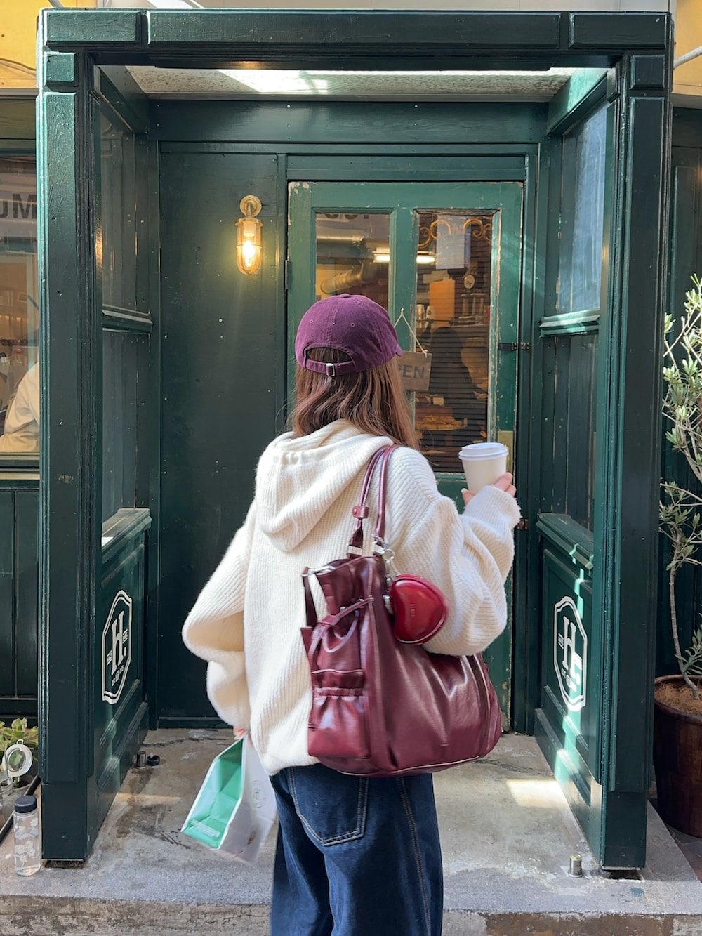 ブルー系のデニムパンツ、ホワイト系のトップス、レッド系のバッグを着用したレディースの冬コーディネートの3枚目の写真