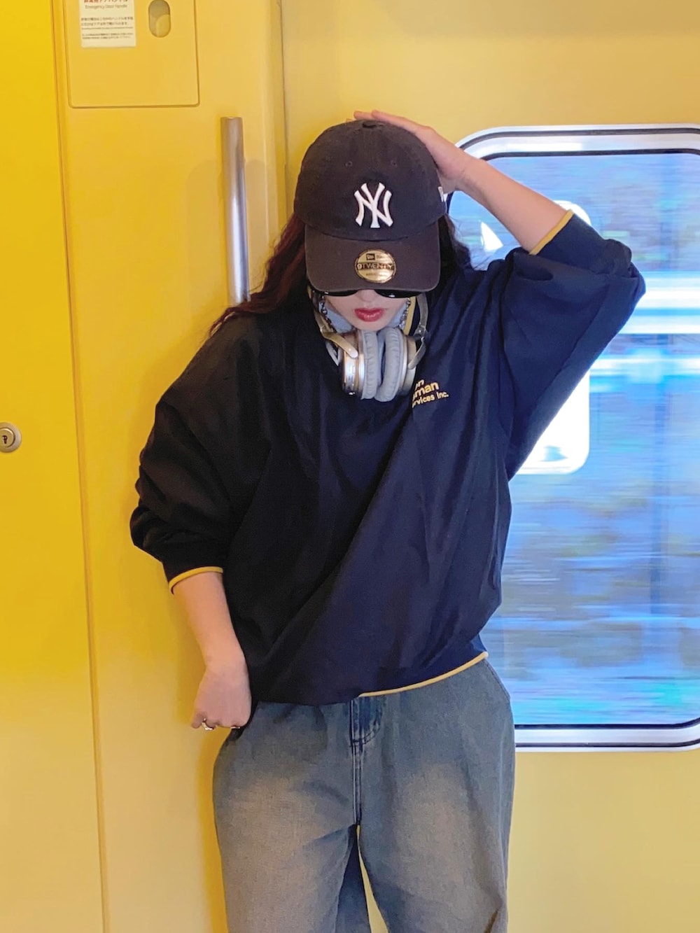 ブルー系のデニムパンツ、グレー系のスニーカー、ブルー系のキャップを着用したレディースの春コーディネートの4枚目の写真