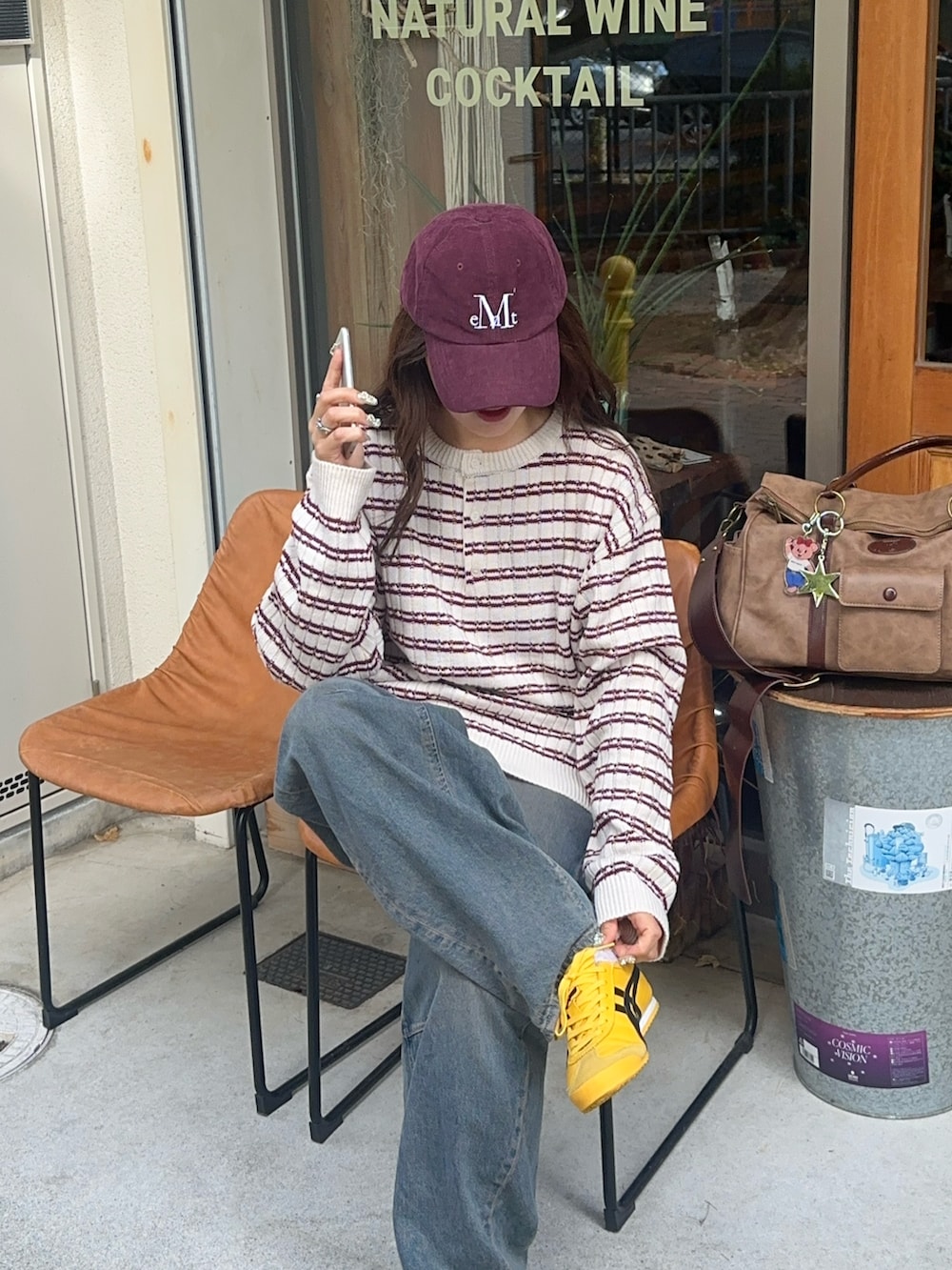 ブラウン系のボストンバッグ、イエロー系のスニーカー、ホワイト系のニット/セーターを着用したレディースの秋コーディネートの4枚目の写真