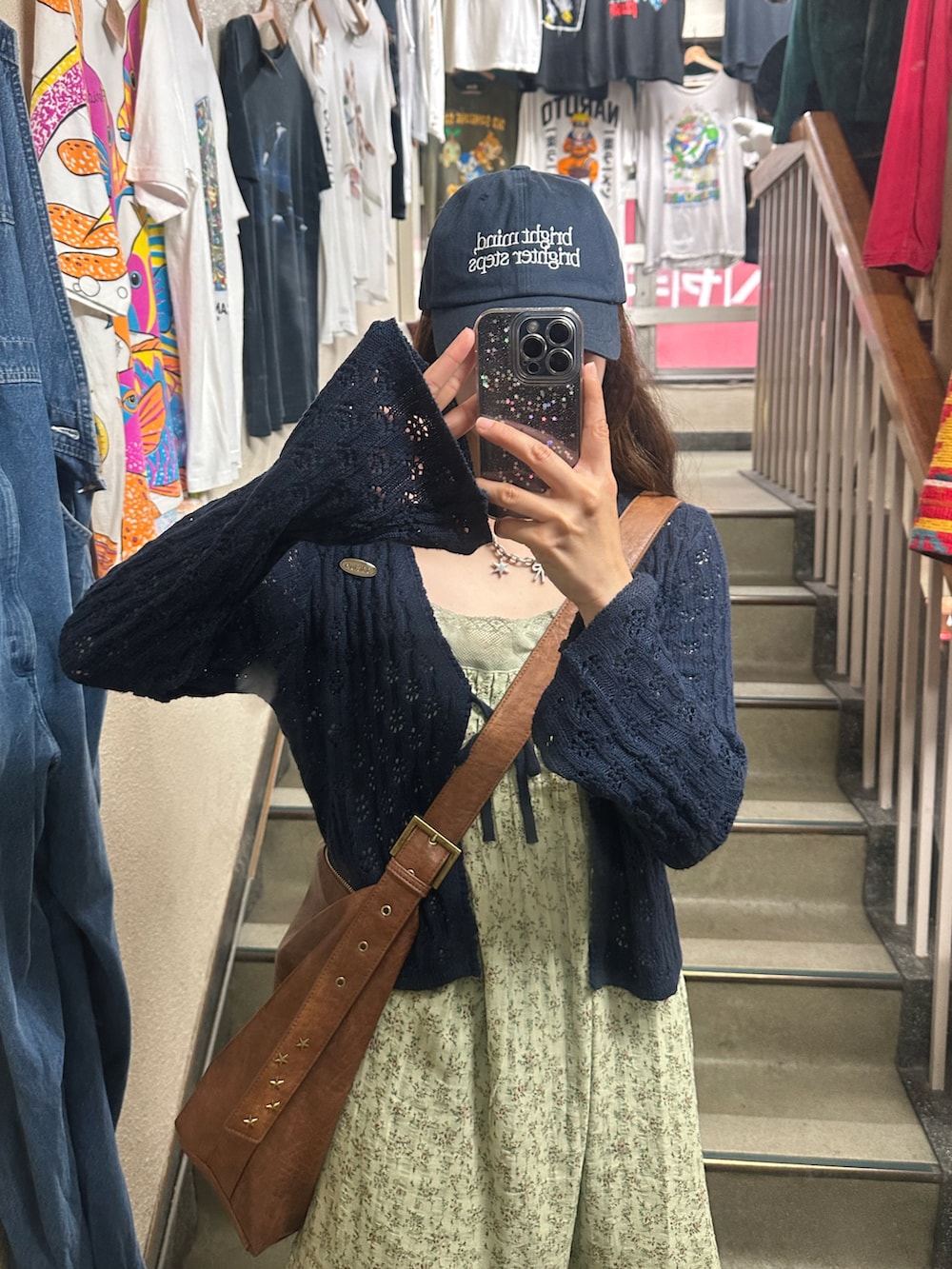 ブルー系のカーディガン/ボレロ、ブルー系のデニムパンツ、ブラウン系のショルダーバッグを着用したレディースの春コーディネートの3枚目の写真