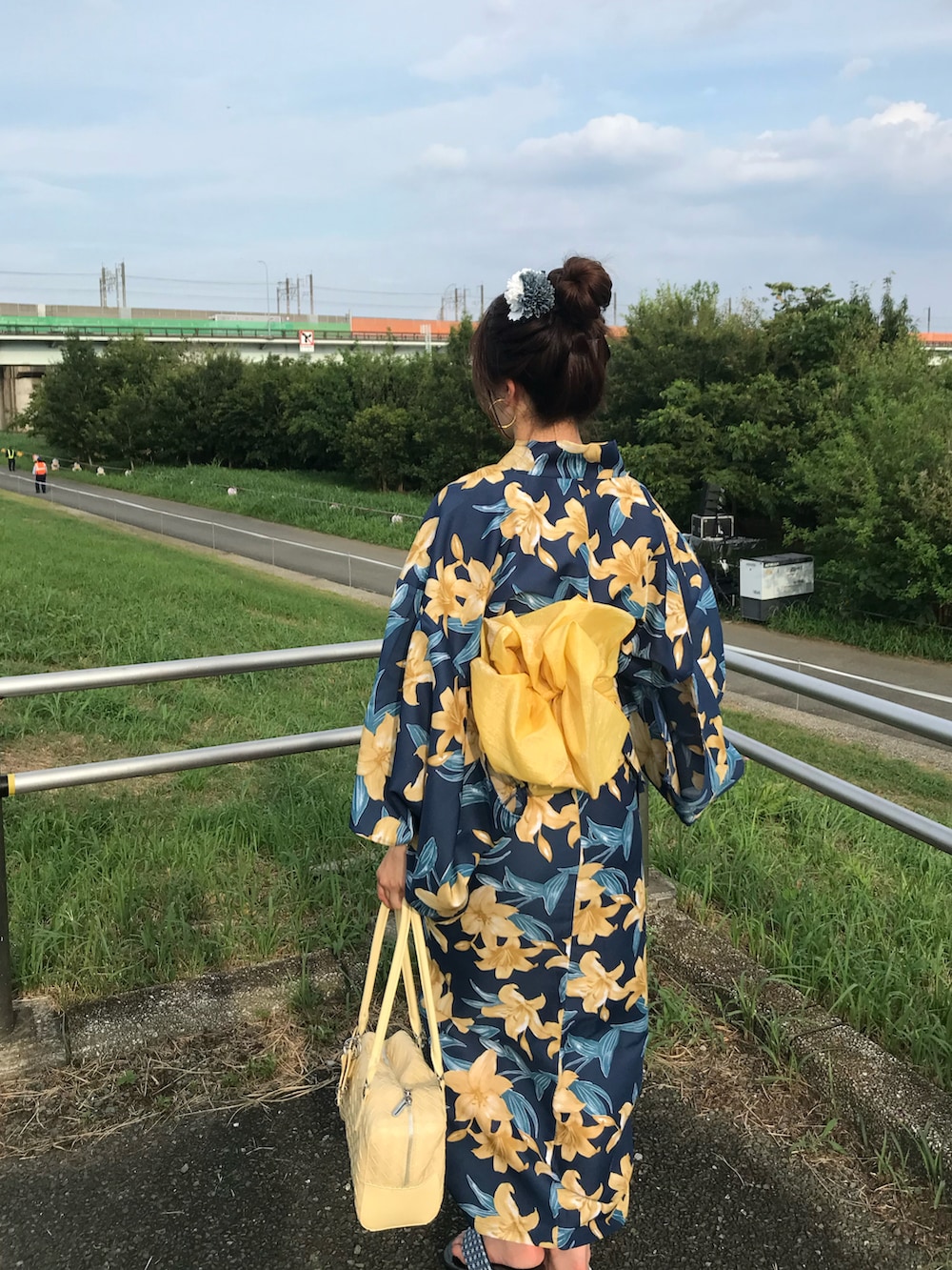 イエロー系のバッグ、ブルー系のシューズ、ブルー系の浴衣を着用したレディースの夏コーディネートの3枚目の写真