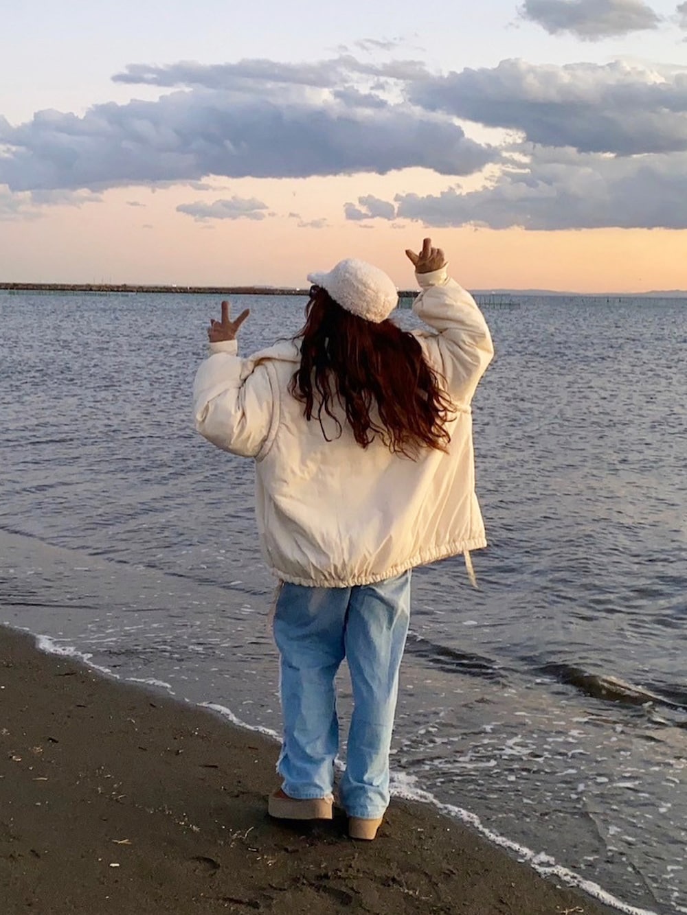 ホワイト系のブルゾン、グレー系のカーディガン/ボレロ、パープル系のマフラーを着用したレディースの冬コーディネートの3枚目の写真