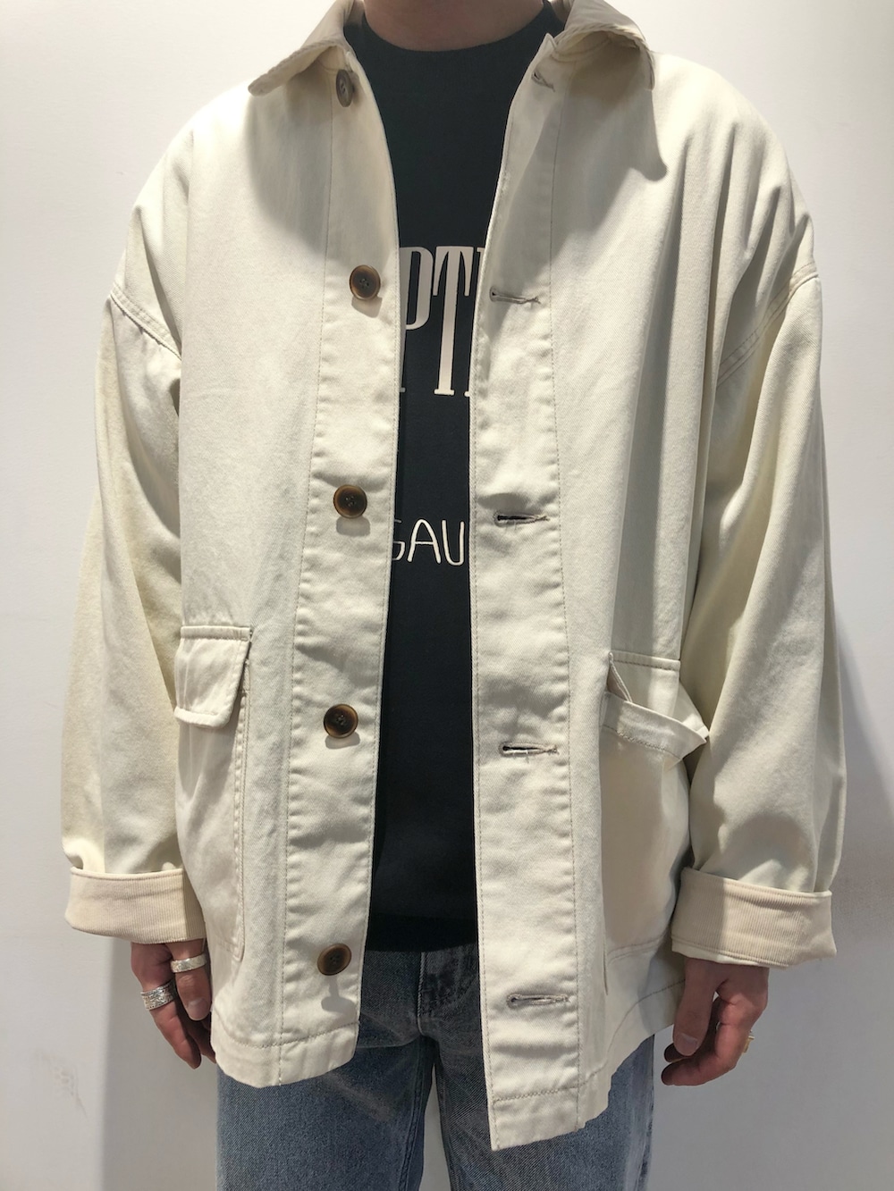 ブラック系のスウェット、ホワイト系のカバーオール、ブルー系のパンツを着用したメンズの冬コーディネートの2枚目の写真