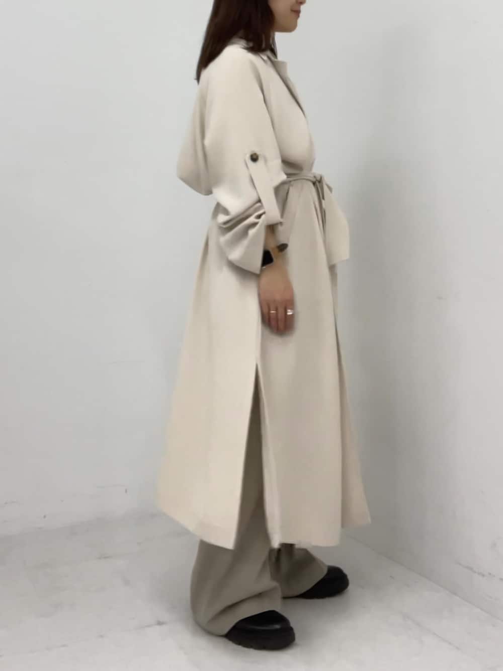 ホワイト系のトレンチコートを着用したレディースの冬コーディネートの4枚目の写真