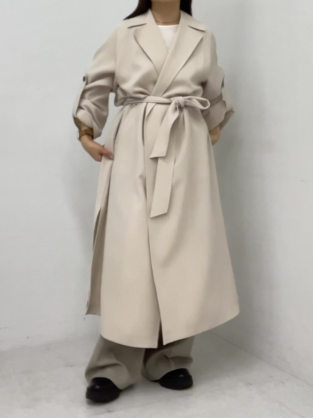 ホワイト系のトレンチコートを着用したレディースの冬コーディネートの3枚目の写真