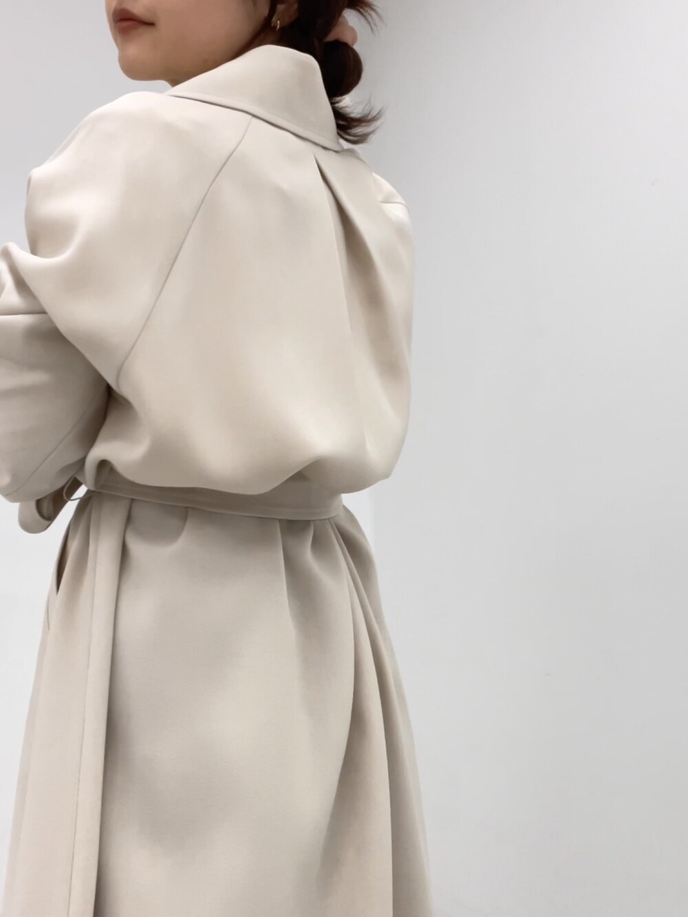 ホワイト系のトレンチコートを着用したレディースの冬コーディネートの2枚目の写真