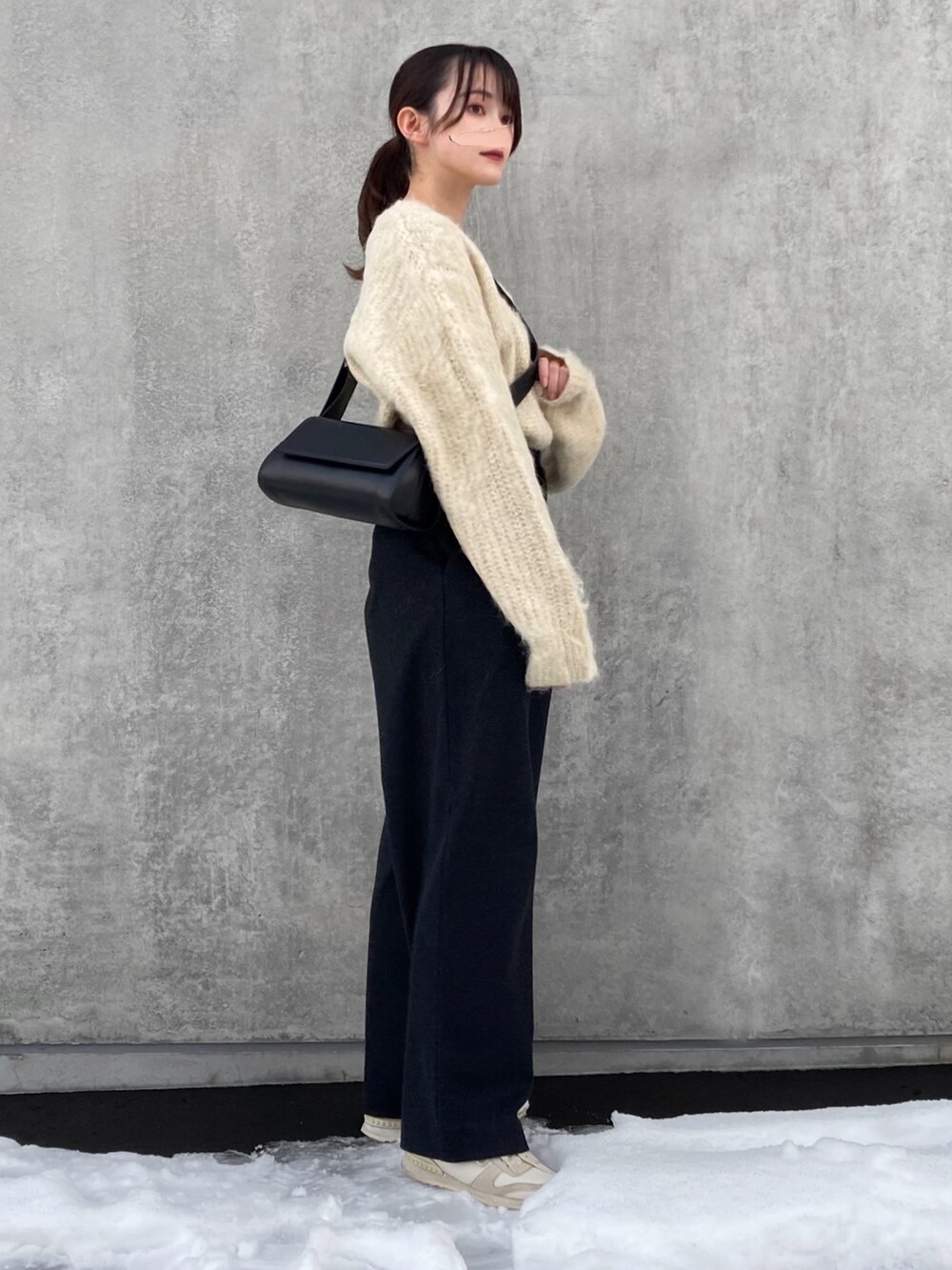 ブラック系のパンツ、ベージュ系のニット/セーター、ブラック系のショルダーバッグを着用したレディースの冬コーディネートの2枚目の写真