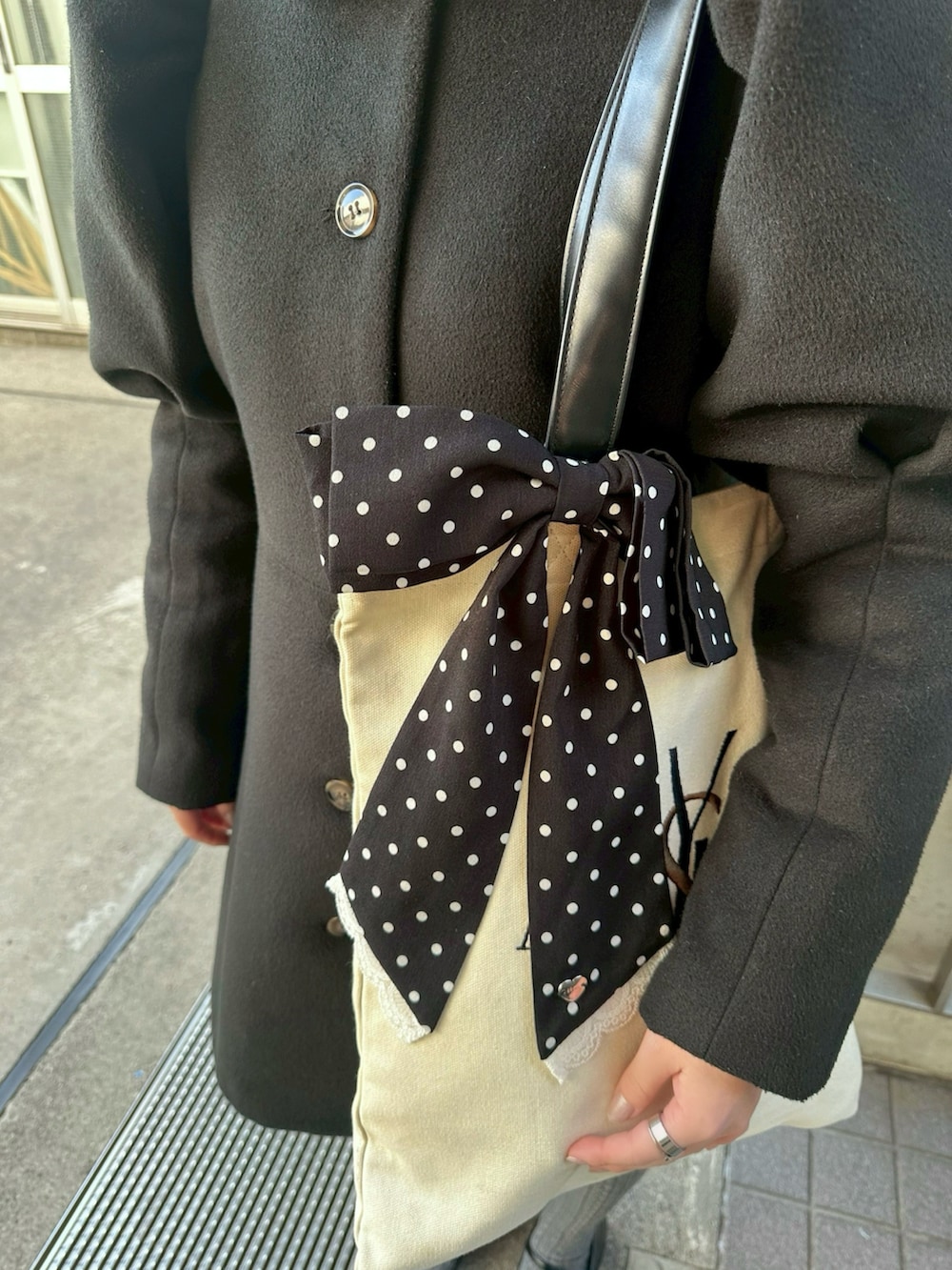 ブラック系のジャケット/アウター、ベージュ系のトートバッグ、ブラック系のパンプスを着用したレディースの冬コーディネートの2枚目の写真