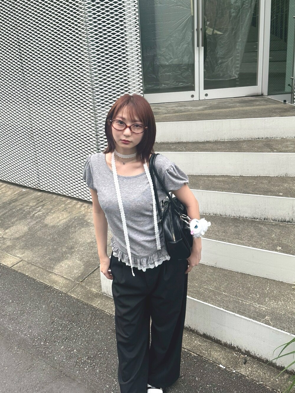 グレー系のTシャツ/カットソー、ブラック系のパンツ、ブラック系のバッグを着用したレディースの夏コーディネートの2枚目の写真