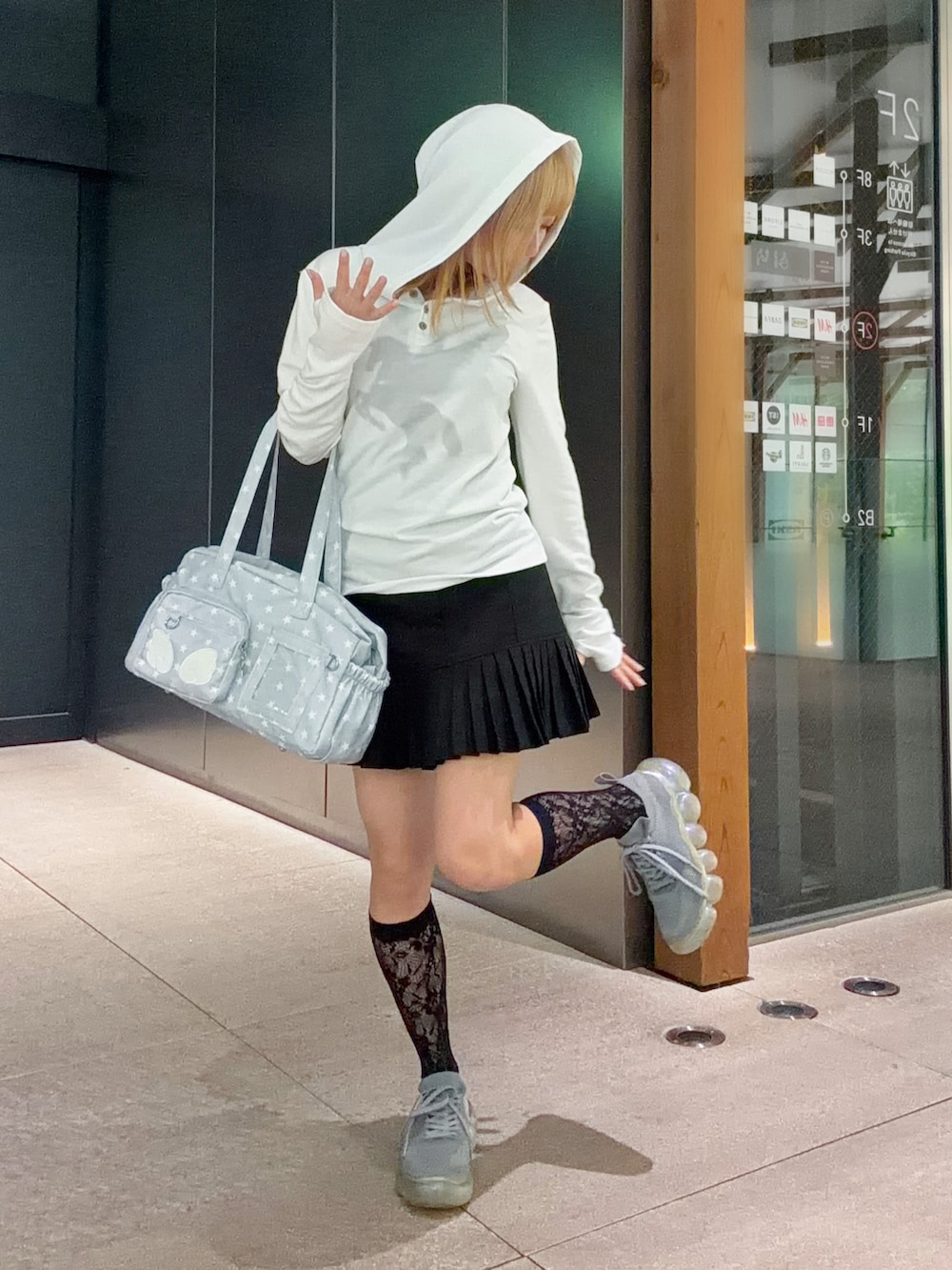ホワイト系のTシャツ/カットソー、グレー系のスニーカー、ブラック系のスカートを着用したレディースの春コーディネートの2枚目の写真